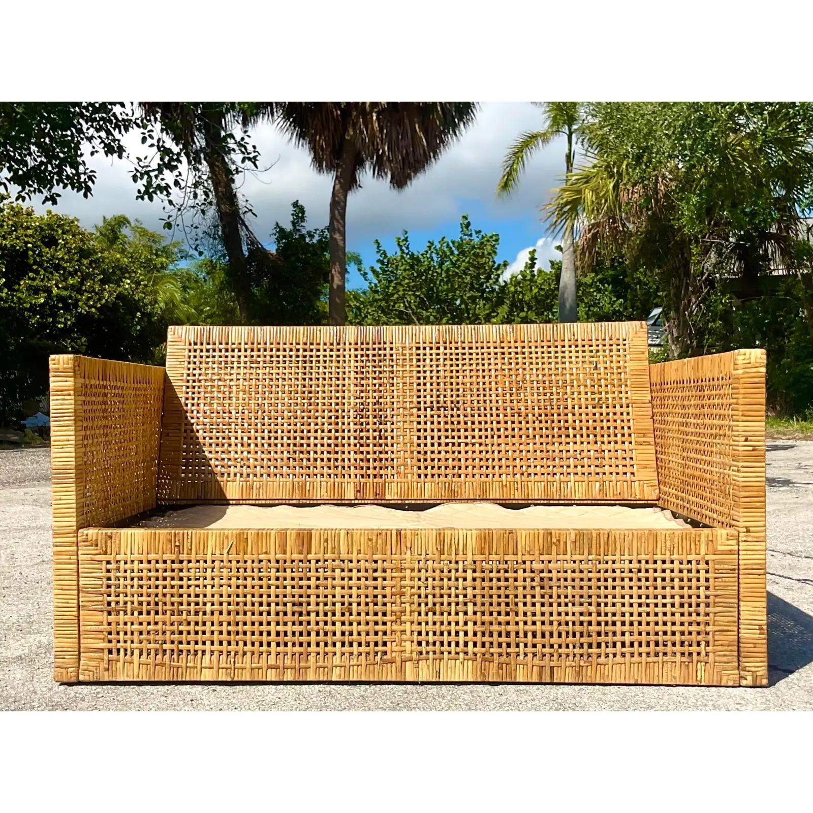 Fantastic vintage coastal loveseat. Beautiful wrapped rattan frame in chic warm browns. Cushions included in the purchase. Acquired from a Palm Beach estate.
