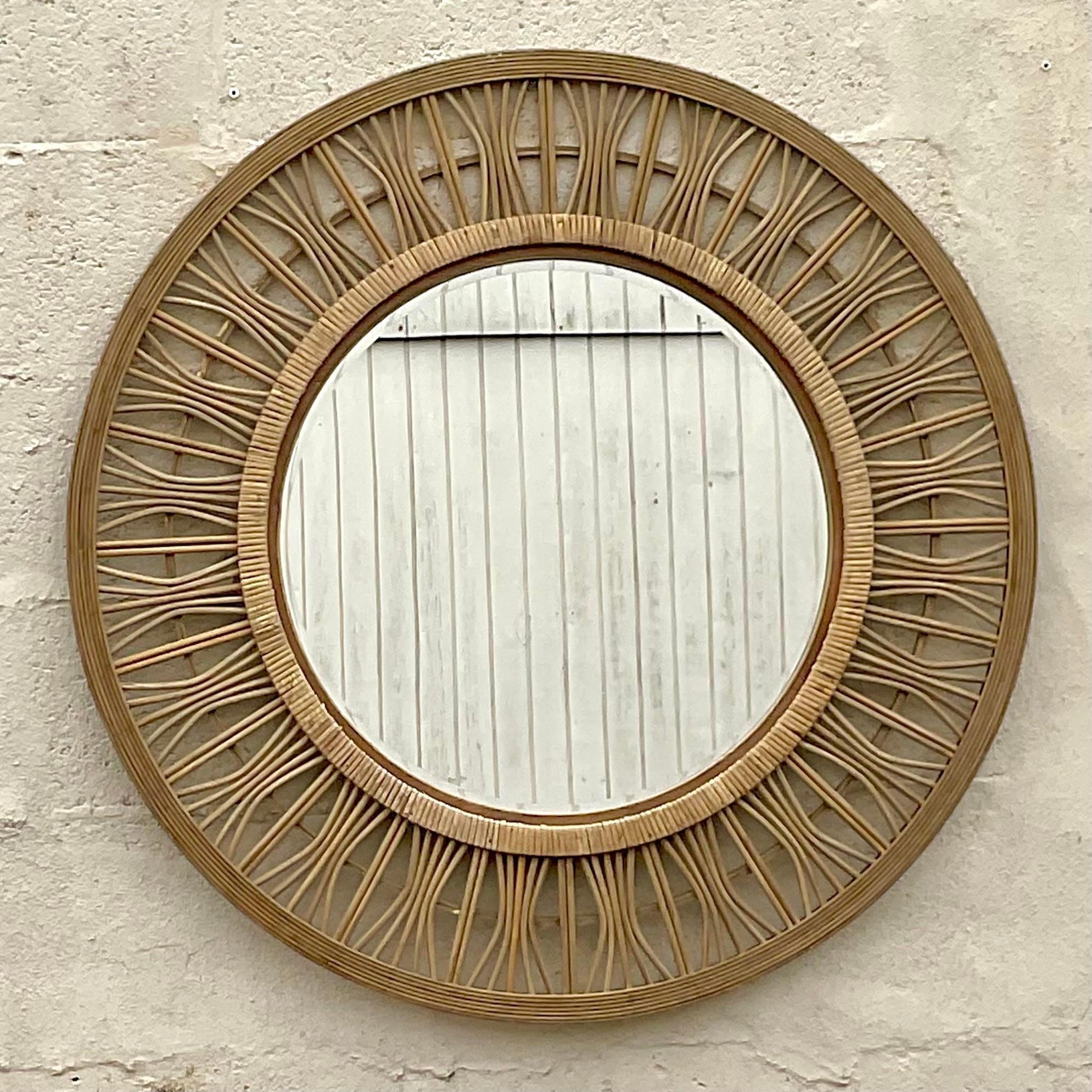 Un fabuleux miroir mural vintage de style côtier. Un beau design en forme de rayon avec des inserts en rotin enveloppés. Acquis d'une propriété de Palm Beach.