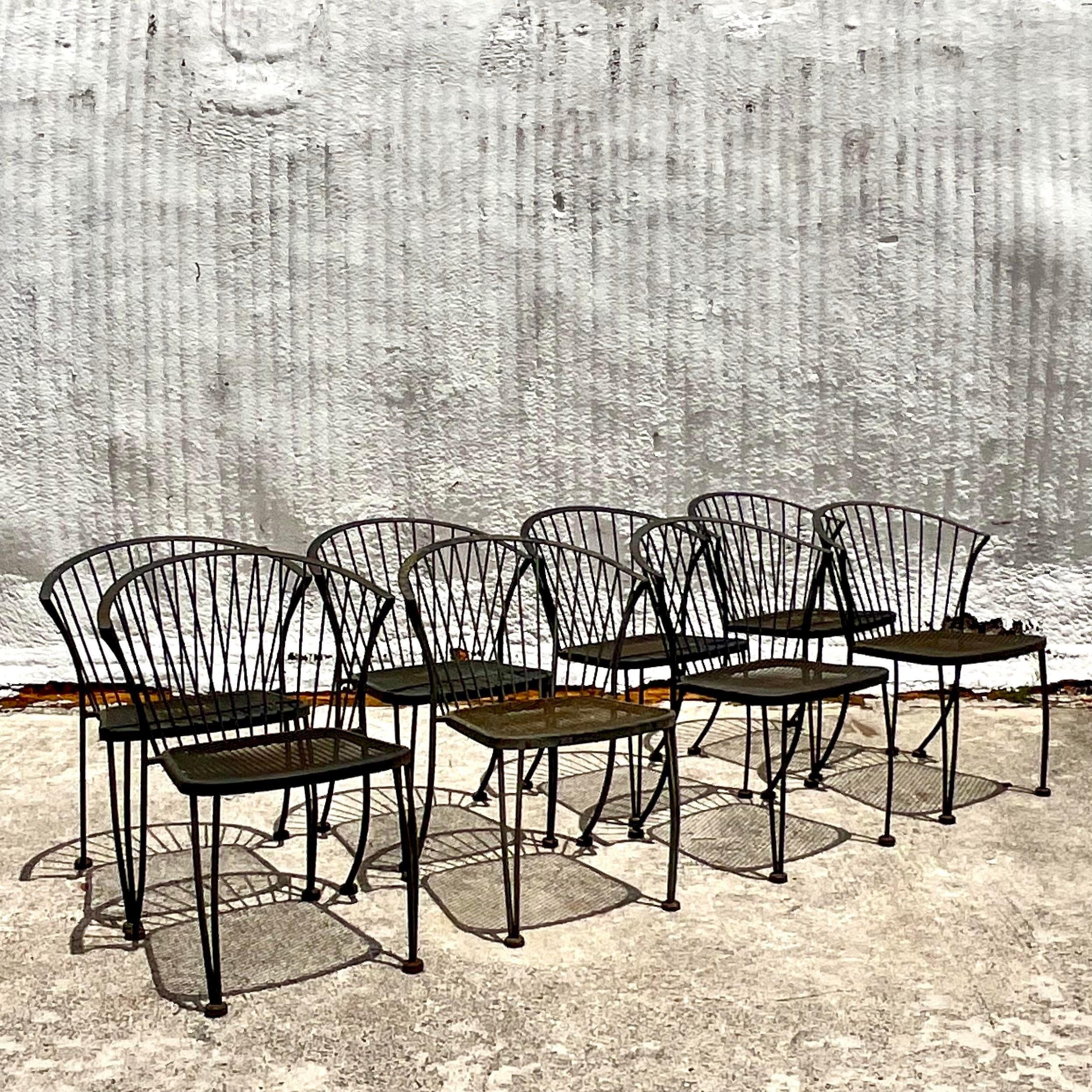 A fabulous vintage Coastal set of dining chairs. A chic and clean design in a painted wrought iron. Done in the manner of Russell Woodard. Acquired from a Palm Beach estate.