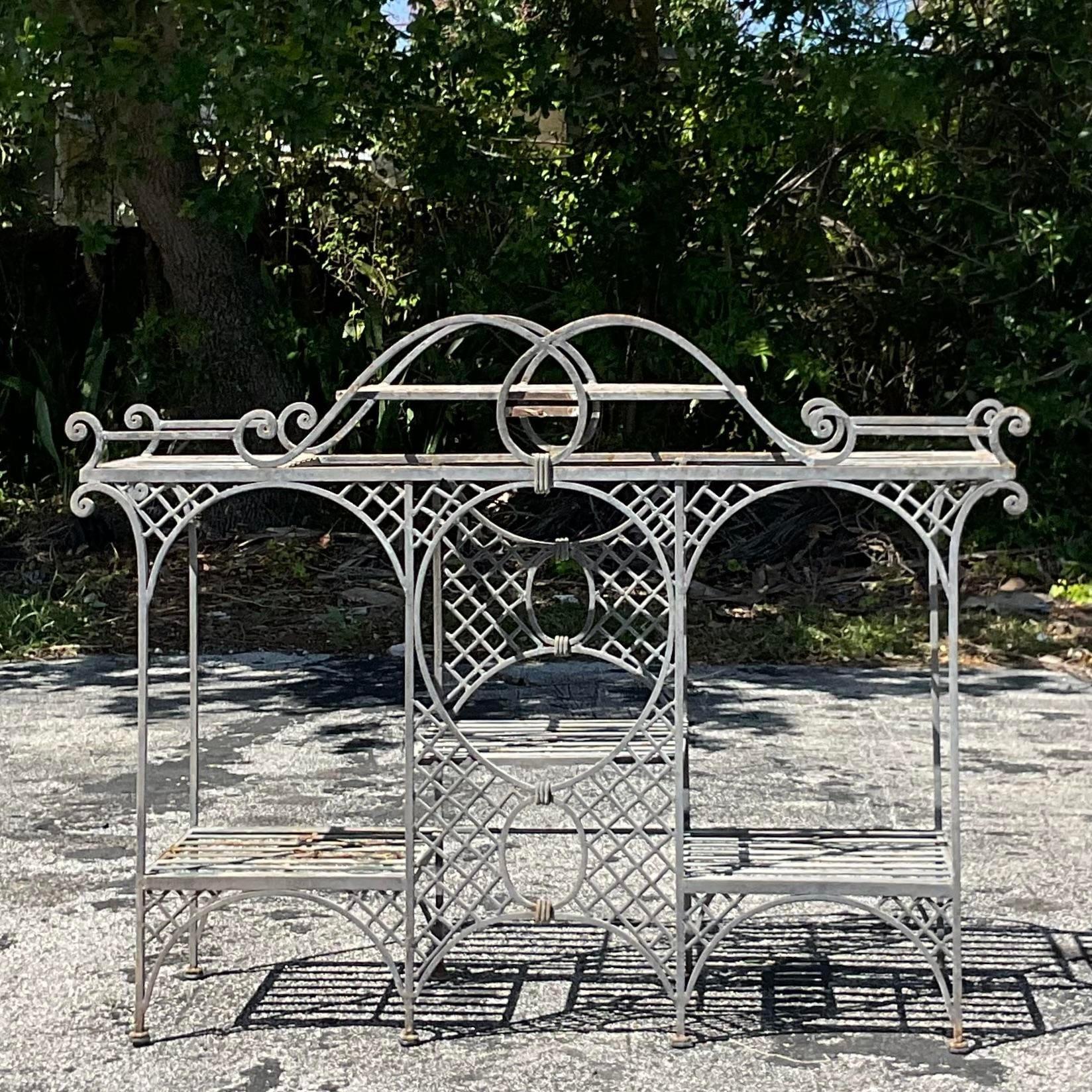 Embrace outdoor elegance with the Vintage Coastal Wrought Iron Trellis Console Table. Crafted with enduring American craftsmanship, this table seamlessly combines coastal charm with functional design. The wrought iron construction ensures durability