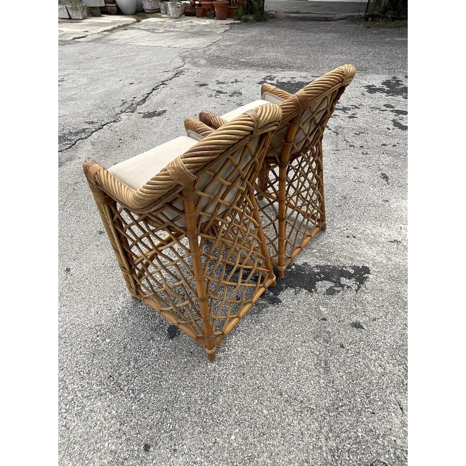 Fabulous pair of vintage Coastal bar stools. Beautiful heavy twisted rattan with panels of trellis design. Acquired from a Palm Beach estate.