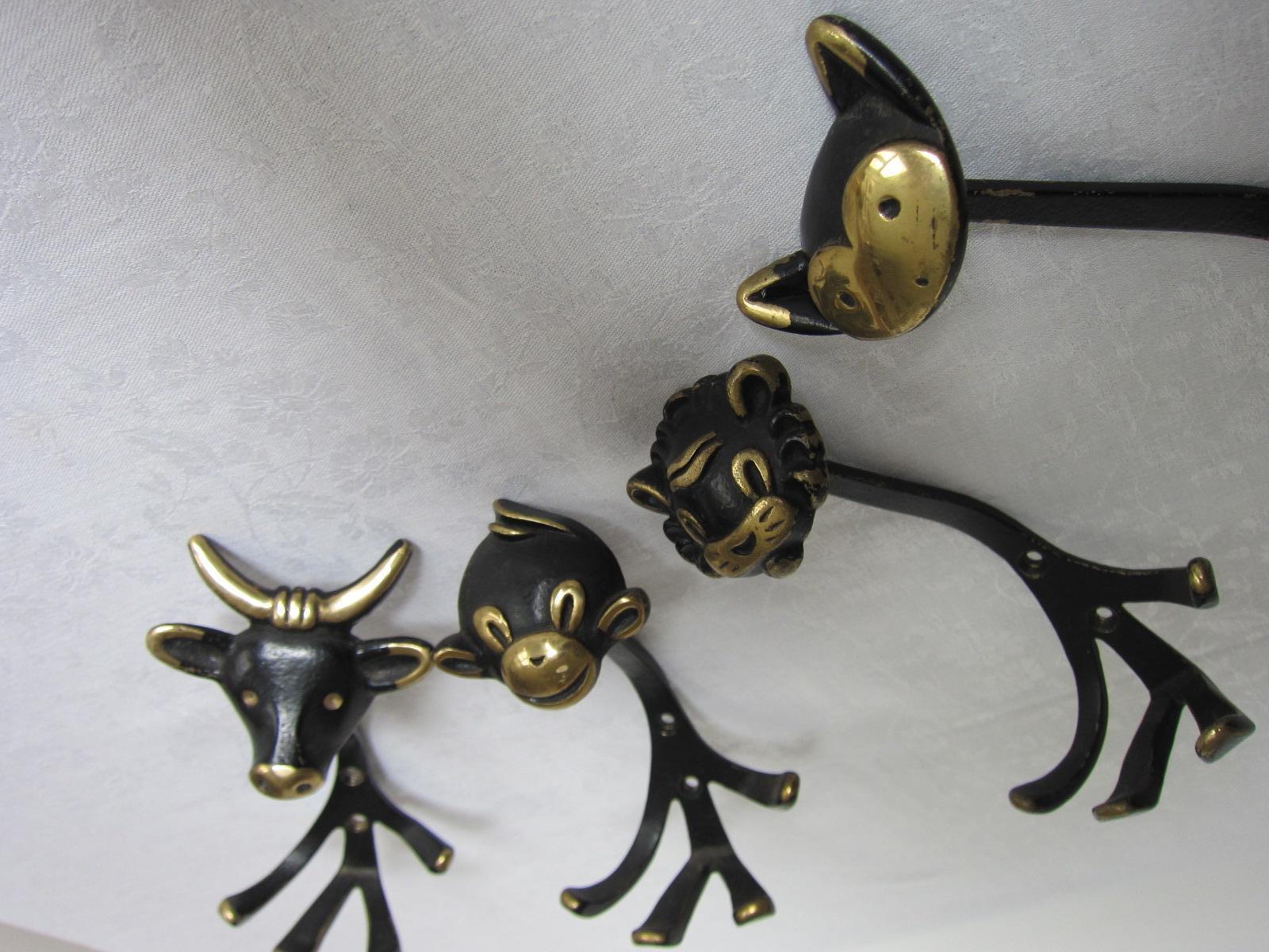 Four vintage Coat hooks from Walter Bosse made around 1950
in shape of cat, lion, cow and monkey

At the end of the 1940s, he developed brass miniatures in the shape of animals. Bosse's love of animals is expressed in these works. Gluttöter and