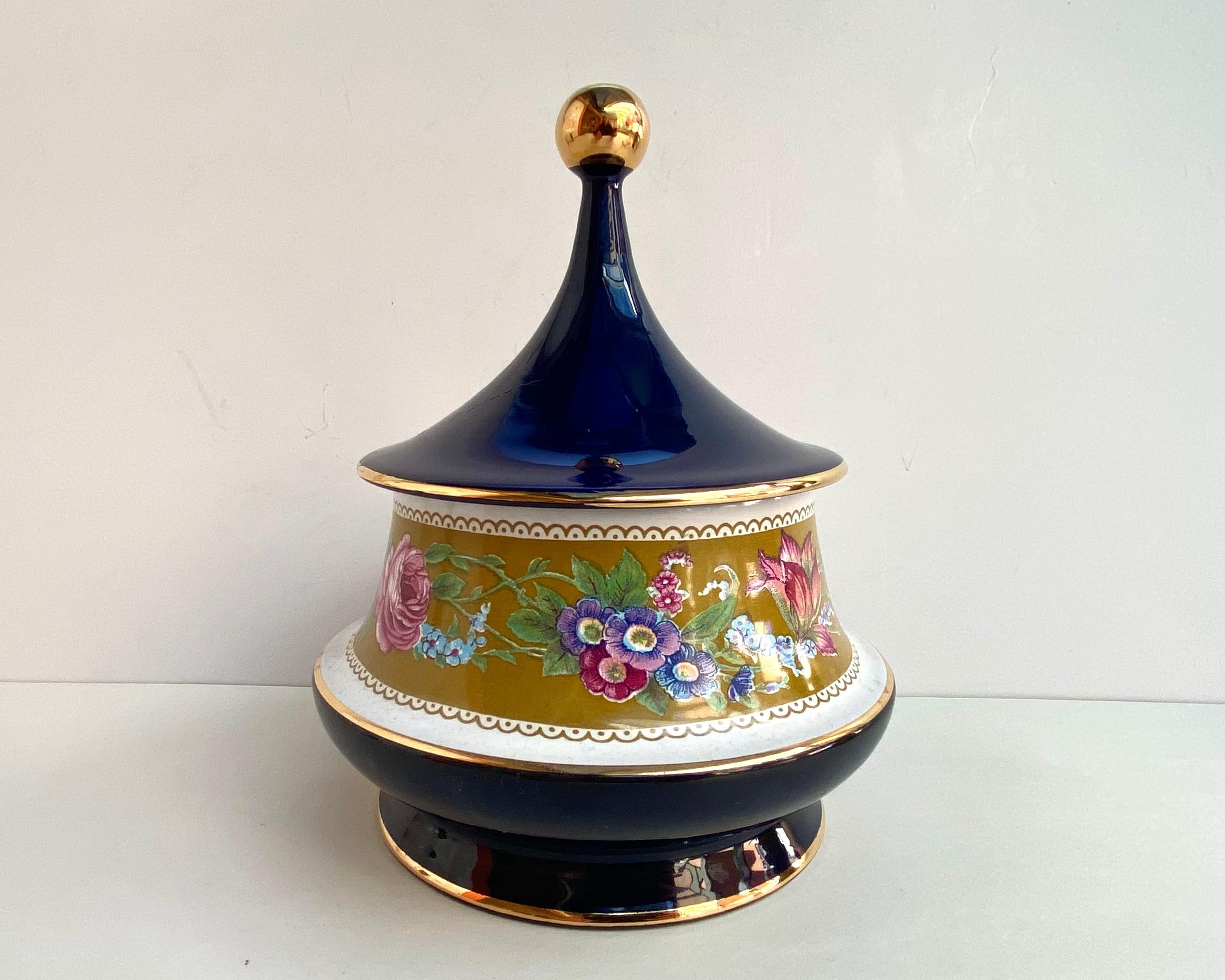 Beautiful ceramic vintage bowl, bonbonniere on a leg with a graceful lid. 

Italy. Around 1970s.

An original combination of white, rich cobalt, laconic gold and delicate floral decor.

All this gives the product an extraordinary chic and will