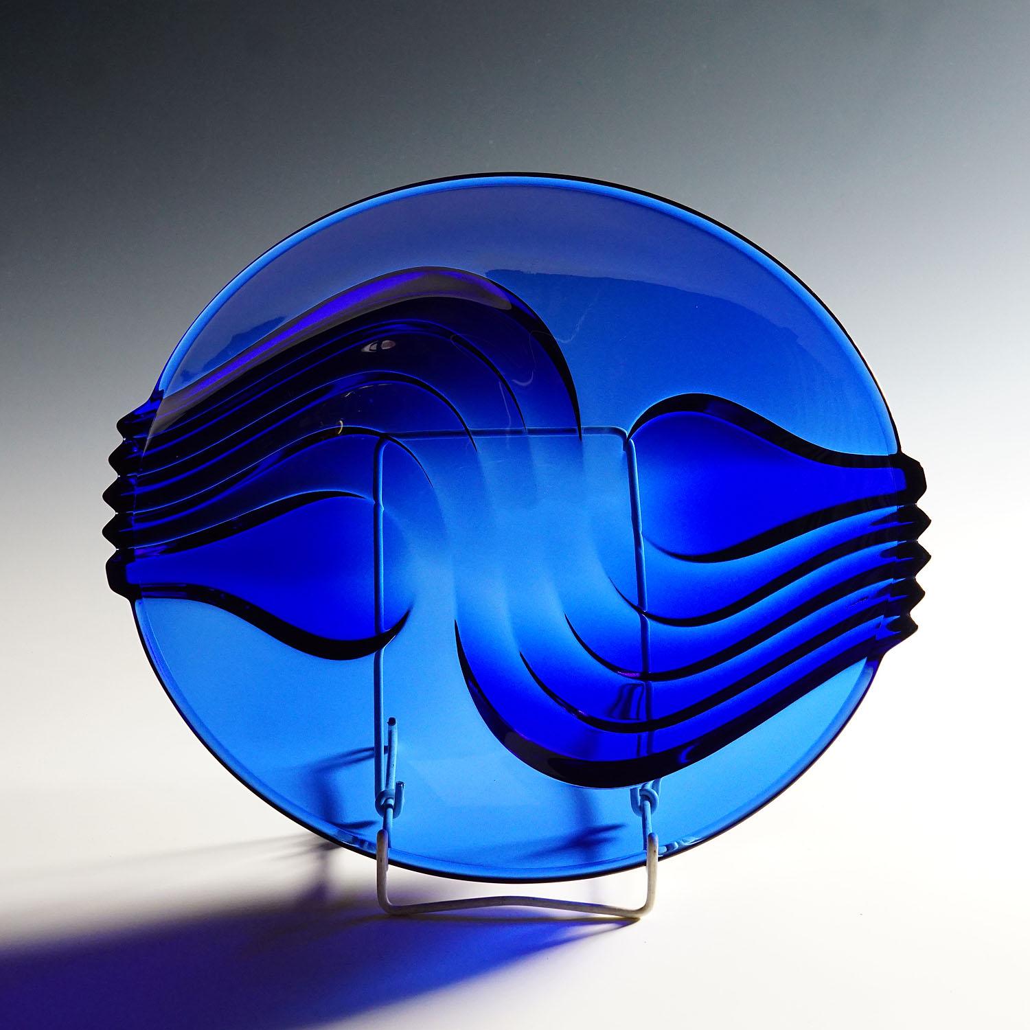Vintage Cobalt blue glass plate by Arcoroc, France

A large pressed glass plate in cobalt blue glass. Manufactured by Arcoroc, France late 20th century. The bowl features a great decoration with undulating lines. Marked with hallmark 