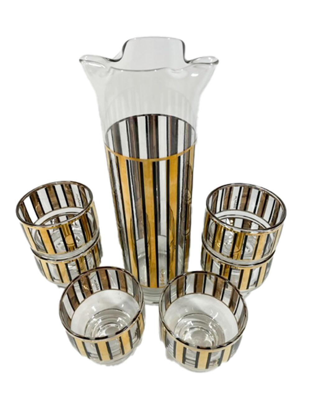 Mid-Century Modern cocktail set by Culver, LTD in the Bandbox pattern. Cocktail pitcher and 6 footed stackable cocktail glasses decorated with 22k gold vertical bars each with a black enamel line along each side.