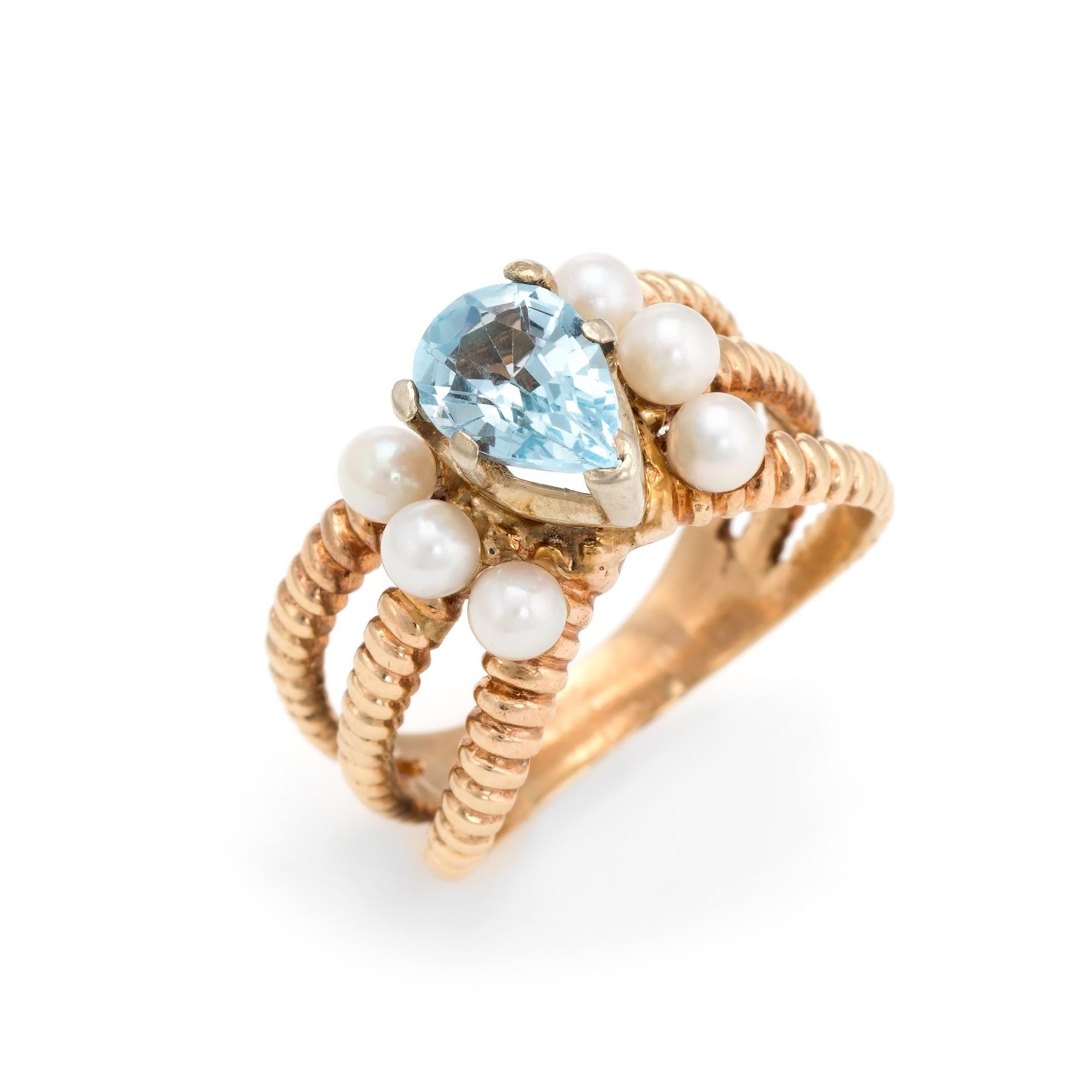Distinct & stylish blue topaz & cultured pearl cocktail ring (circa 1960s to 1970s), crafted in 14 karat yellow gold. 

Faceted pear cut blue topaz measures 9mm x 7mm (estimated at 1.50 carats), accented with six 3.5mm cultured pearls. The topaz is
