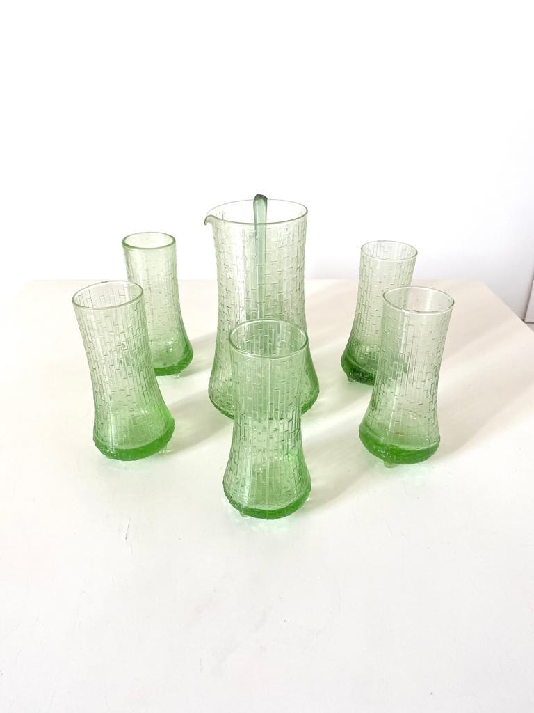 Vintage Green Glass cocktail / drink set composed by six green glass and one jug. Refined hand made glass finishing. In very good conditions.

Jug: 20 height x 11 diametre

Glasses: 16 height x 7 diametre.