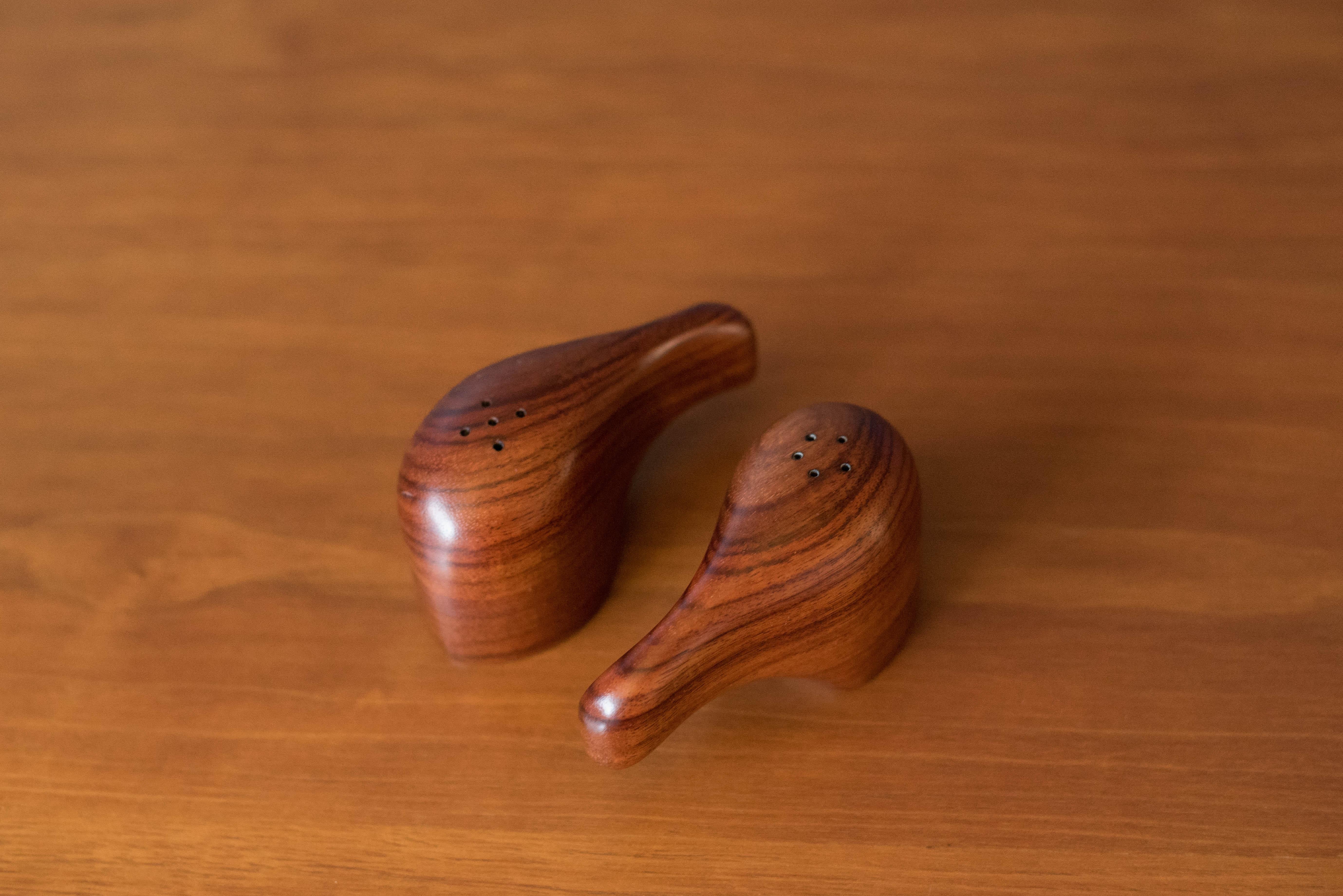 Mid-Century Modern abstract salt and pepper shakers designed by Don Shoemaker for Señal, S.A. Mexico. This set is handmade in an exotic cocobolo wood displaying rich smooth grains for a standout tabletop setting. Price is for the pair.