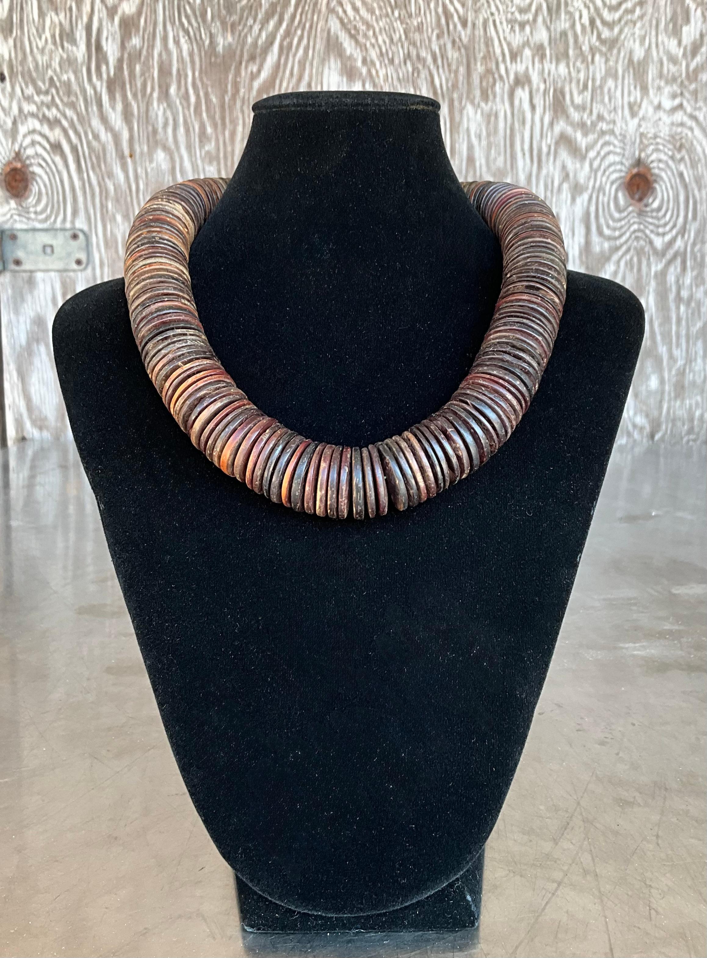 Este collar vintage de cuentas de disco de cáscara de coco es una hermosa pieza terrosa y orgánica que captura el espíritu del diseño natural hecho a mano. Elaboradas con cáscara de coco de origen sostenible, cada cuenta en forma de disco está