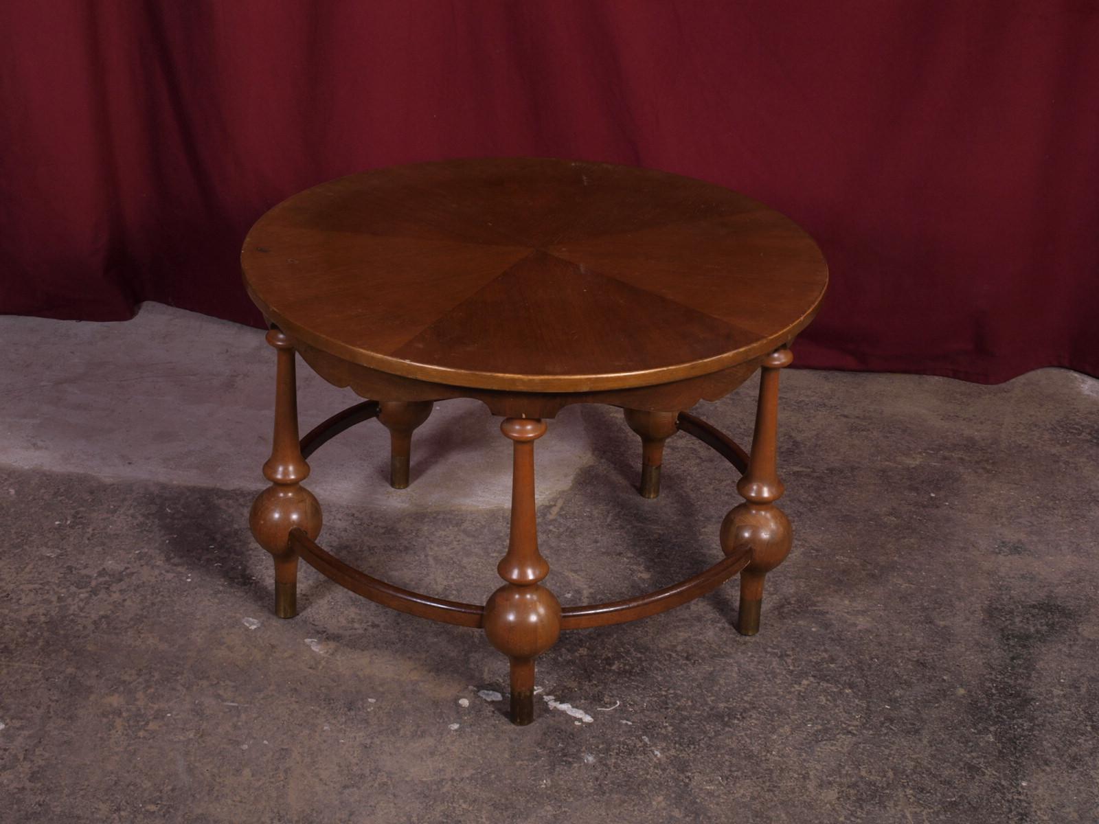This vintage coffee table is a one-of-a-kind piece that will bring character and charm to your living room. The brass shoes, wooden globes, and handmade curves give it a unique and interesting design. It was made in the early to mid-20th century and