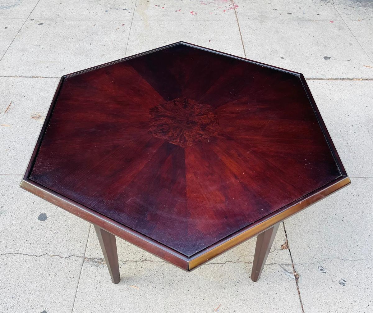 Hexagonal coffee table from the 1950s in the style of Maurice Bailey for Monteverdi-Young.

The table has beautiful lines, finished in a dark walnut, the center has burlwood inlay.

Good vintage condition.

Measurements:
39 inches wide x 45
