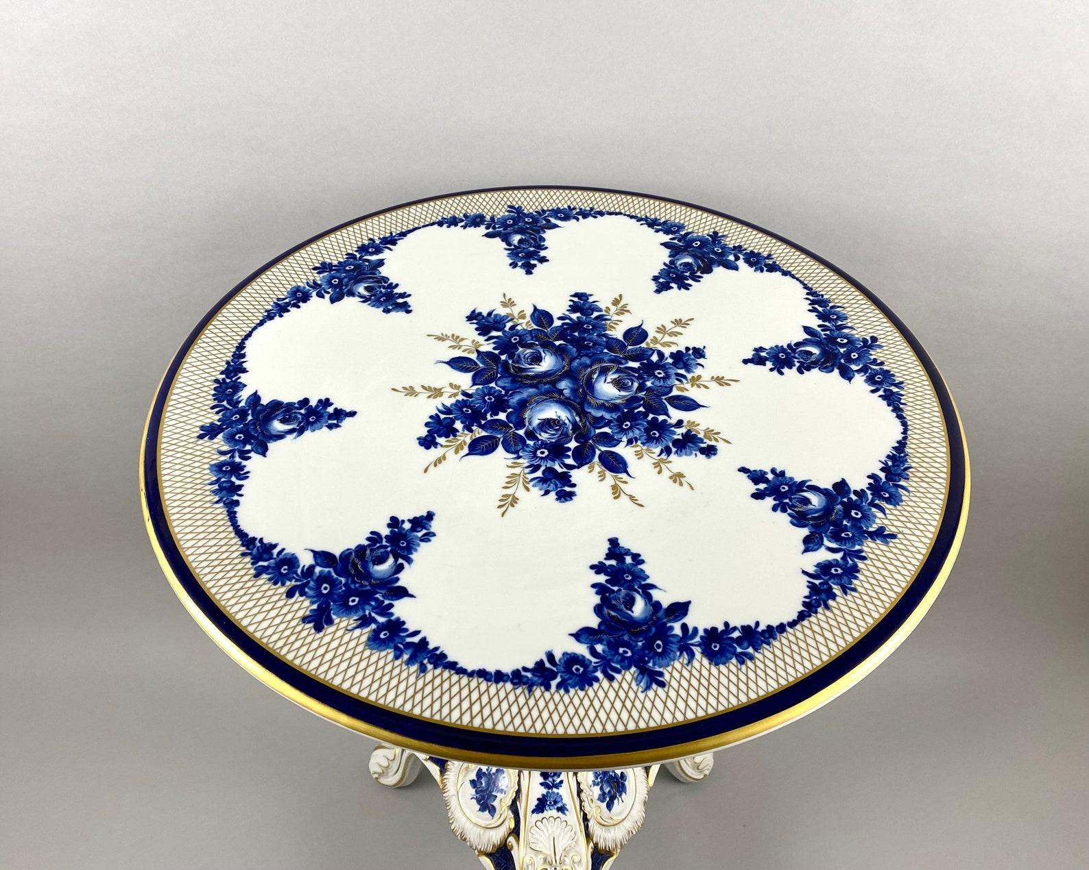 Vintage Couchtisch aus kobaltblauem Porzellan, in den 1980er Jahren. 

 Stil Louis 15, Rokoko. 

 Signatur des Künstlers
RMR 1817 Dresden, Deutschland. 

 Handgemalte Blumendekoration in Kobaltblau und Gold vor weißem Hintergrund. 

 Mit