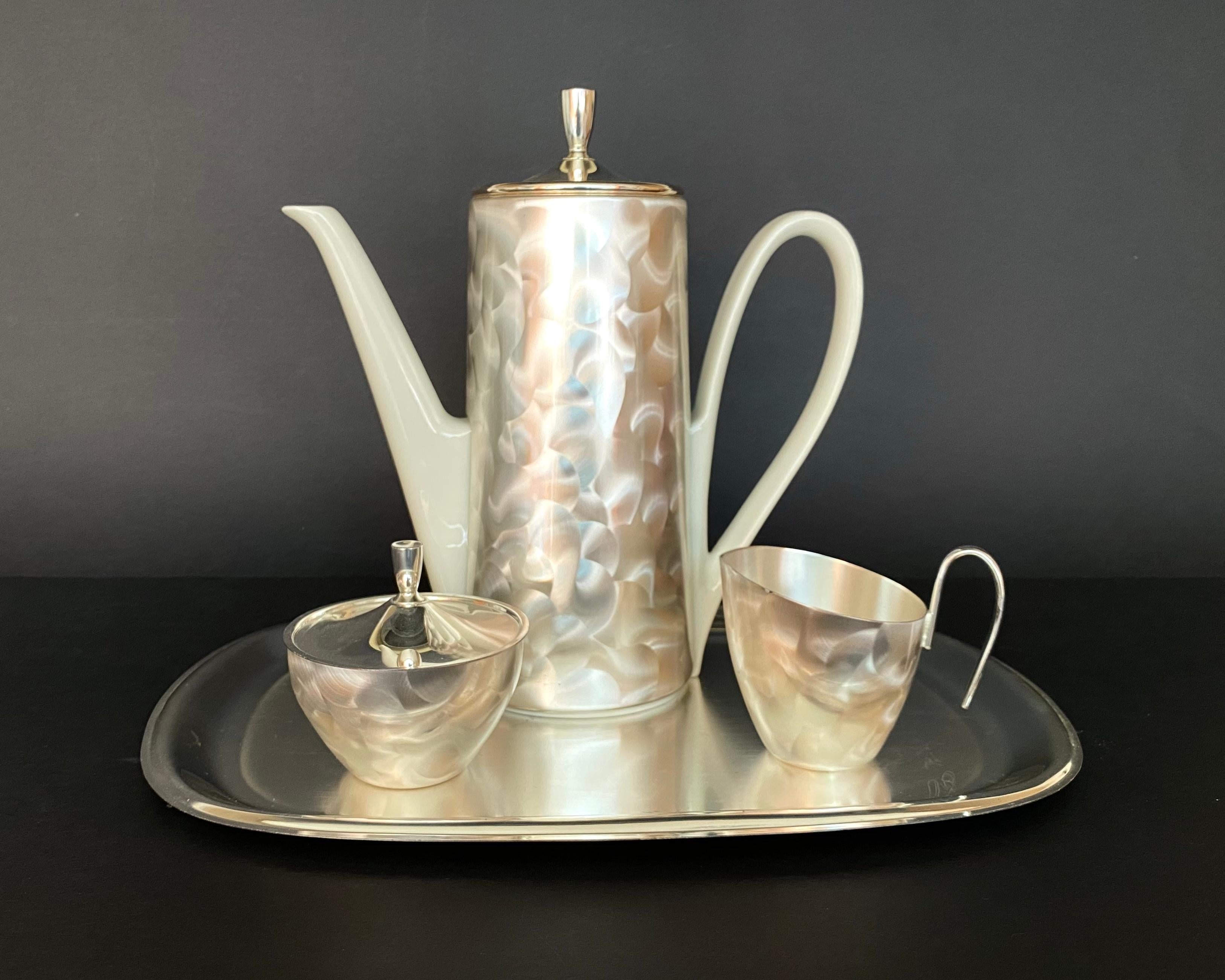 Elegant New Metal Coffee/Tea Set.

Porcelain Teapot, Creamer, Sugar Bowl & Tray By BMF Bavaria, Germany, 1970. 

Coffee Pot With removable thermal hood to keep warm insulated with felt on the inside.

Beautiful set in Bauhaus style.

Marked
