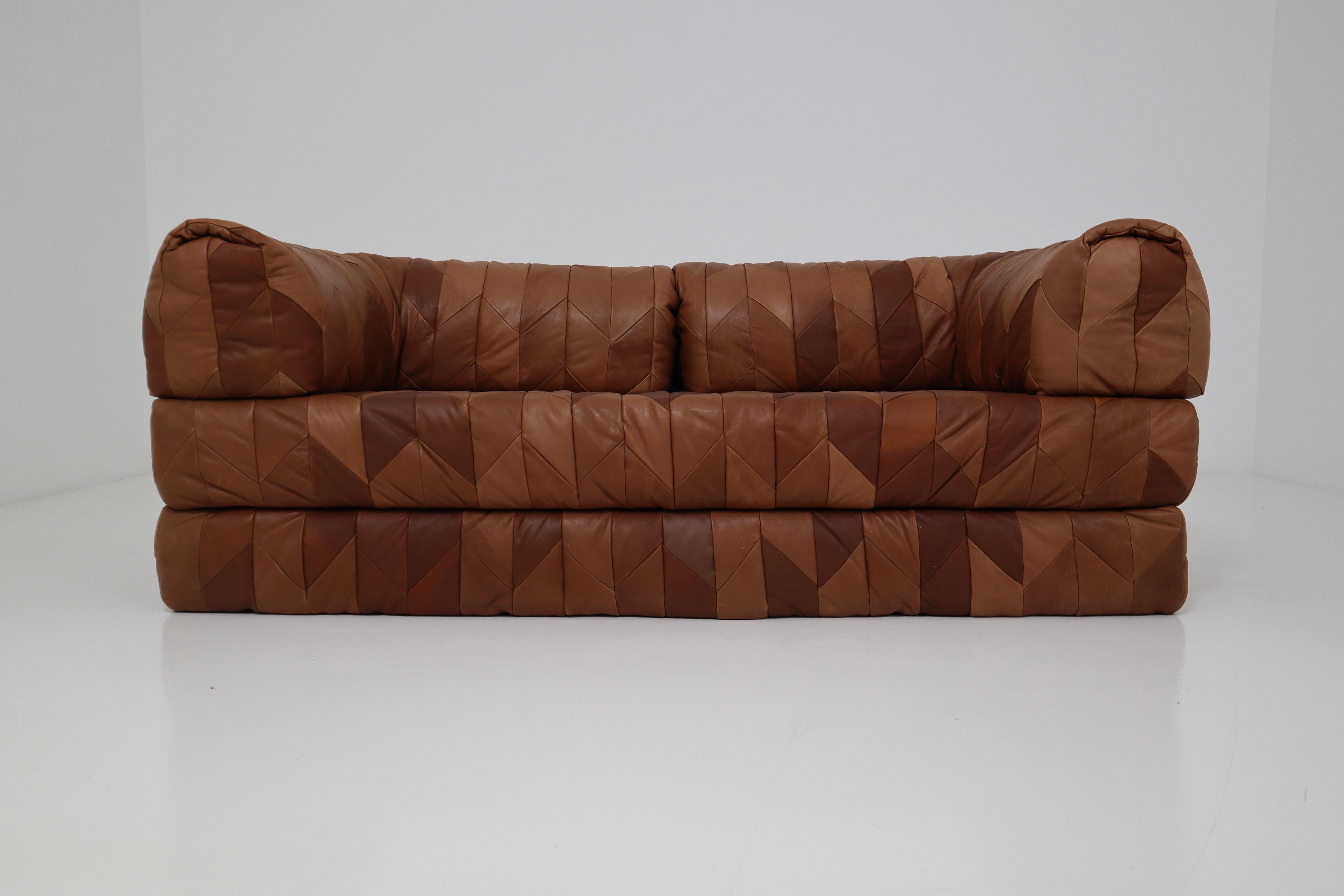 We are delighted to bring to you a highly desirable retro cognac leather patchwork daybed and sofa. Rarely available and built in the 1970s in Europe, this versatile retro daybed doubles up as a sofa and loveseat. This extremely comfortable sofa can