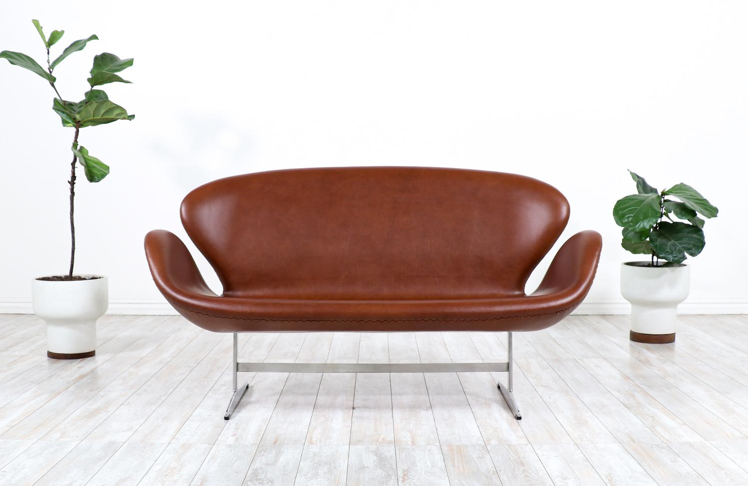 Originally designed for the SAS Royal Hotel in Copenhagen, the Swan sofa by Danish design pioneer, Arne Jacobsen, has become iconic and synonymous with Danish Modern. Reupholstered in a gorgeous new cognac Full-Grain Leather, this comfortable design