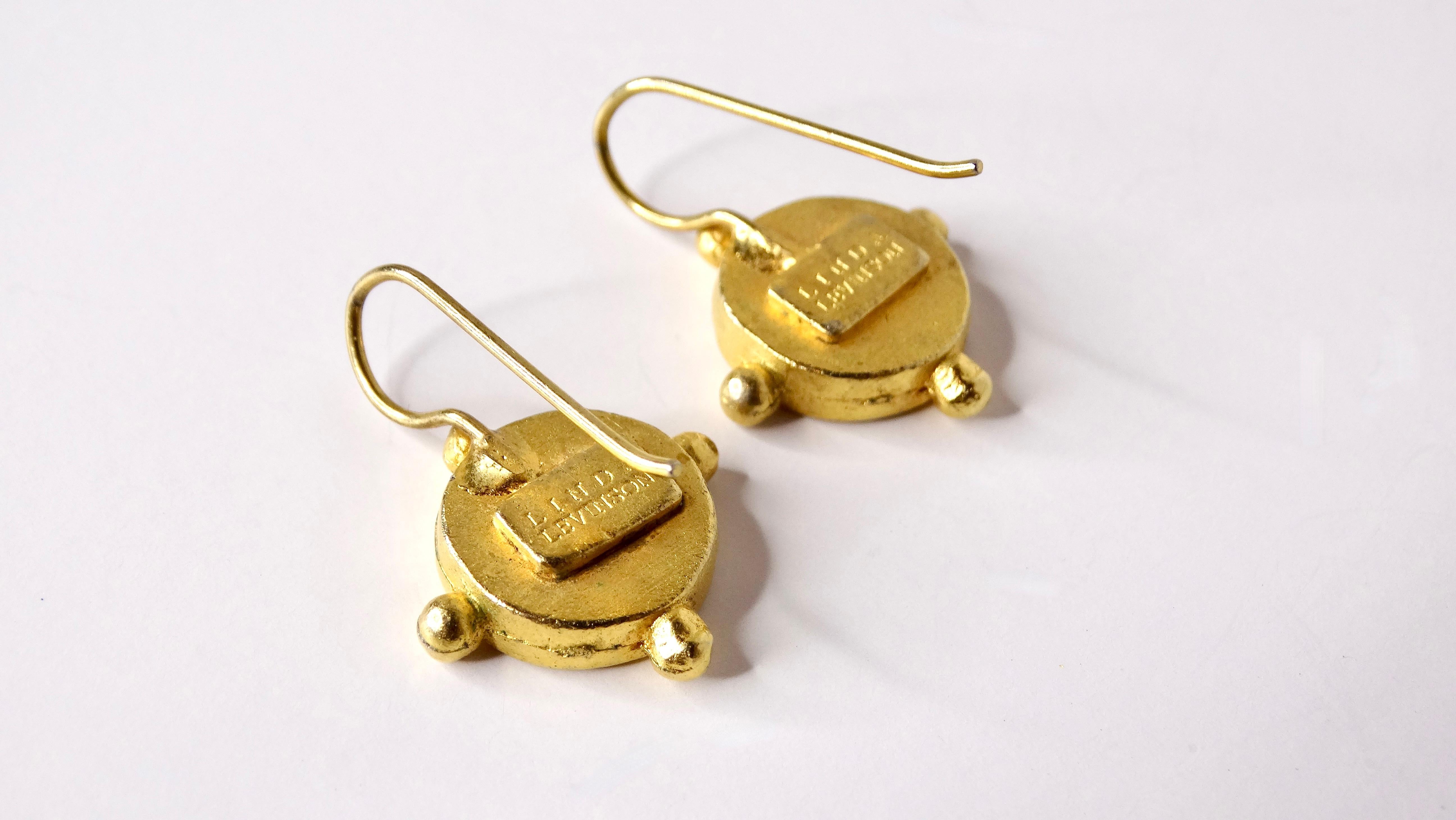 Descubre la elegancia de los pendientes colgantes Vintage Coin bañados en oro de 18 quilates, cuidadosamente diseñados por Linda Levinson. Estos exquisitos pendientes presentan un diseño de moneda único que desprende una sensación de sofisticación
