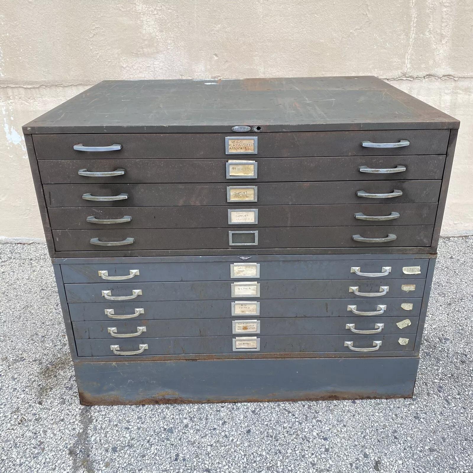 Archivador plano apilable vintage Cole Steel de metal industrial con 10 cajones. El artículo consta de (3) piezas con (1) base y (2) secciones de cajones apilables. Una sección es verde militar y la otra gris, y cada sección tiene tiradores de cajón