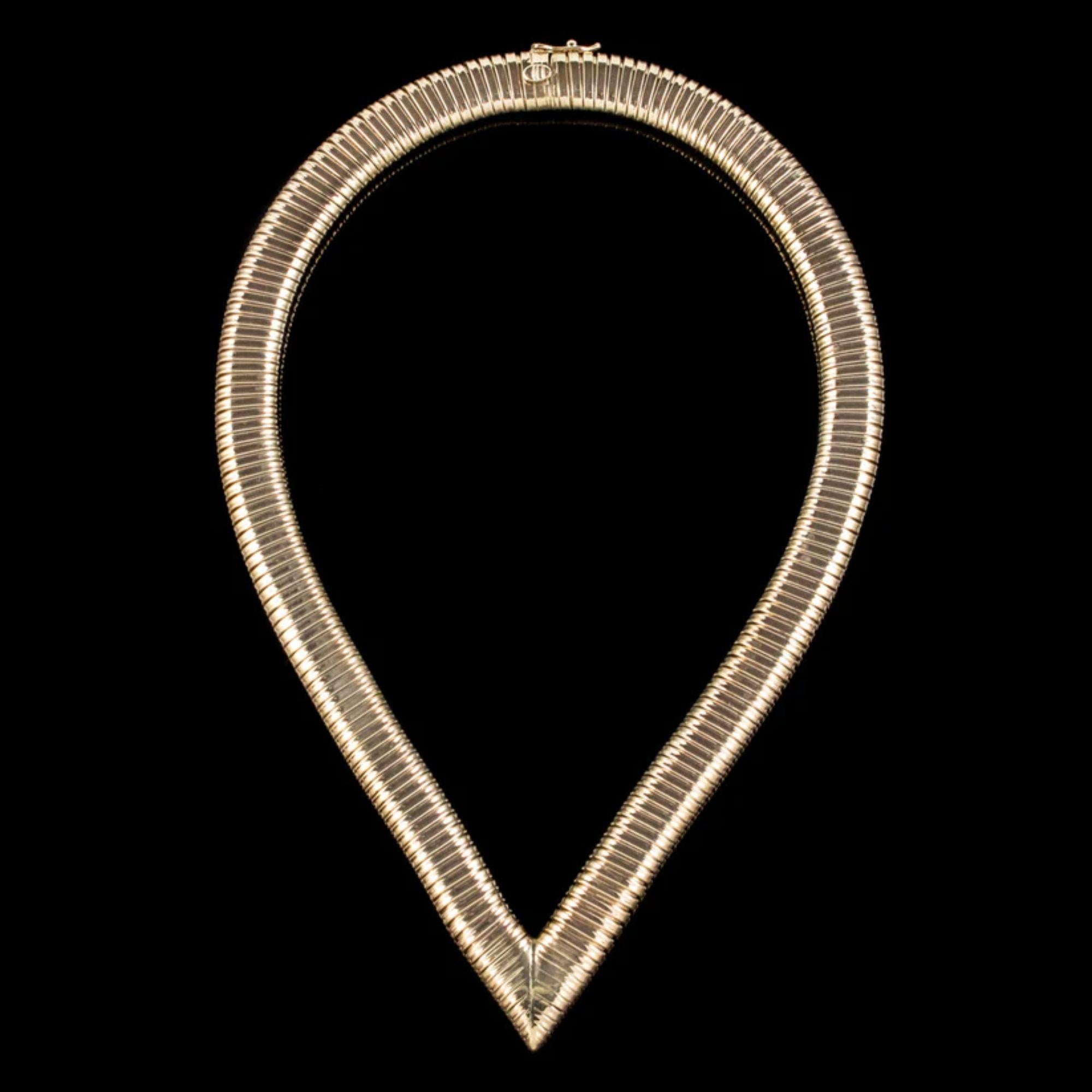A remarkable mid 20th Century snake collar with a thick 9ct Yellow Gold band that comes to a signature point at the bottom. Its ingenious design is articulated and expands to fit comfortably around the neck when worn.

It’s very distinctive and