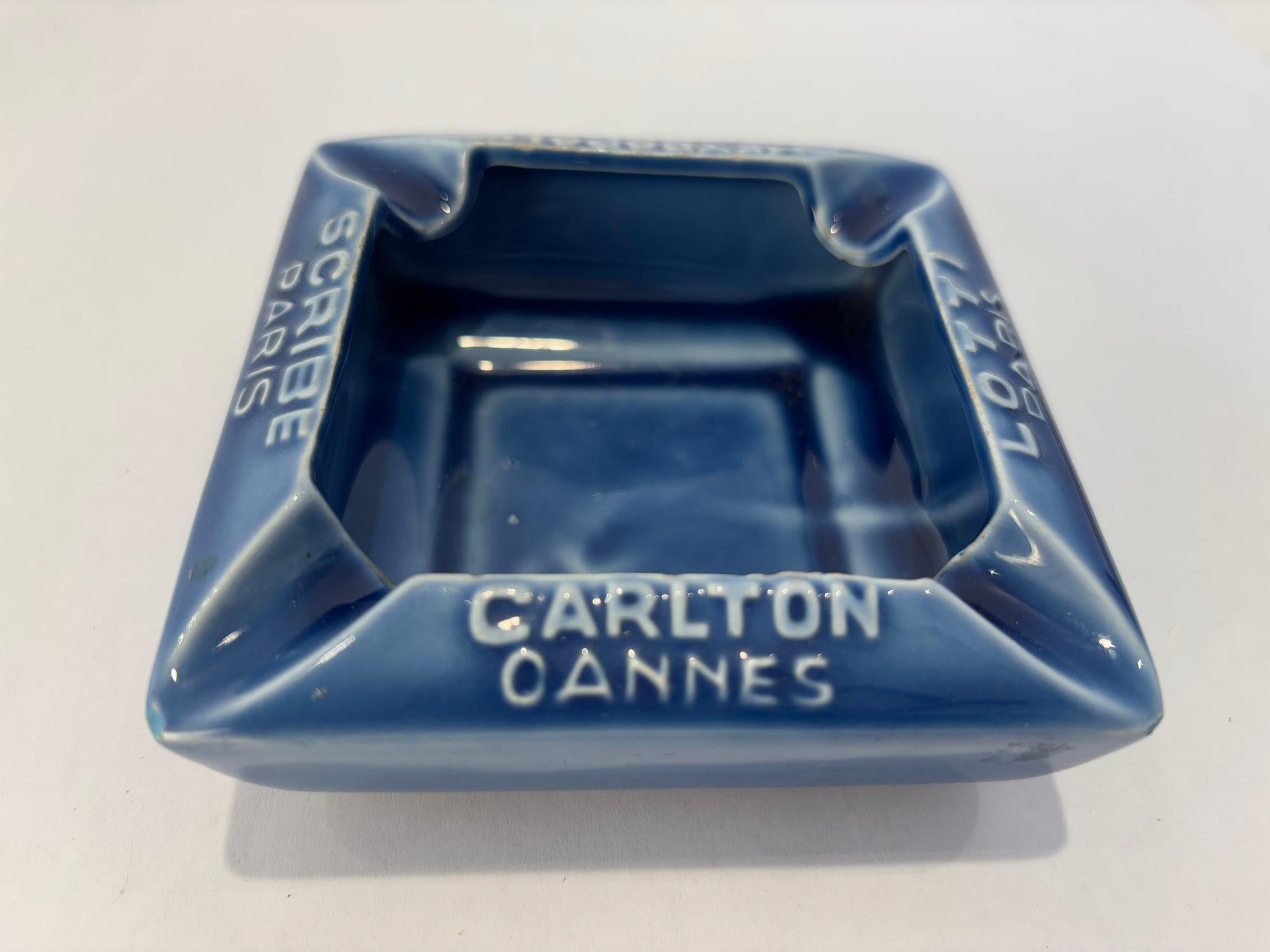 Bellissimo posacenere vintage da collezione in ceramica blu francese con i simboli dell'hotel.
Realizzato in Francia da Proceram Aubagne En Provence, questo splendido posacenere in ceramica smaltata blu oceano rende omaggio a celebri monumenti