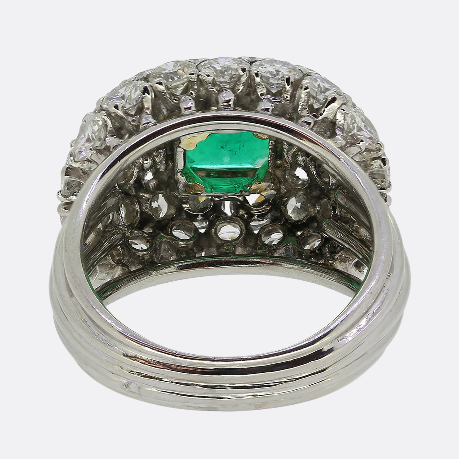 Hier haben wir einen ganz besonderen Smaragd- und Diamant-Bombenring. Der Ring stammt aus den 1960er Jahren und zeigt einen sehr begehrten sattgrünen kolumbianischen Smaragd, der in einer erhöhten Fassung sitzt. Der Smaragd ist SSEF-zertifiziert und