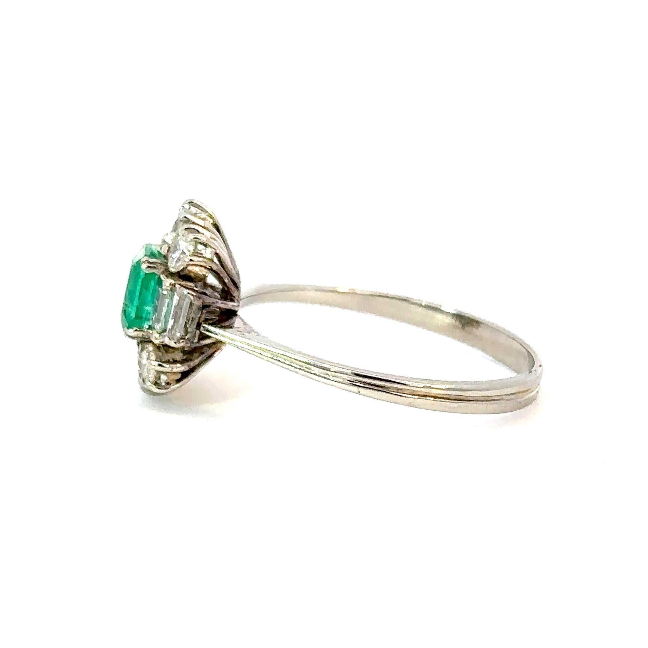 Ein raffinierter Vintage-Ring mit Smaragd und Diamanten aus 18 Karat Weißgold, mit einem leuchtenden kolumbianischen Smaragd, umgeben von funkelnden Diamanten.
In der Mitte liegt ein 0,50 ct natürlicher Smaragd im eleganten achteckigen