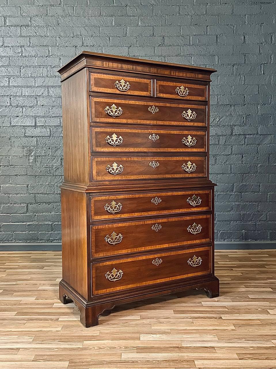 This exquisite Colonial Revival highboy dresser by Drexel, crafted in the 1950s, captures the essence of timeless sophistication. Made from rich mahogany, its striking grain pattern and elegant brass hardware exude warmth and refinement. The