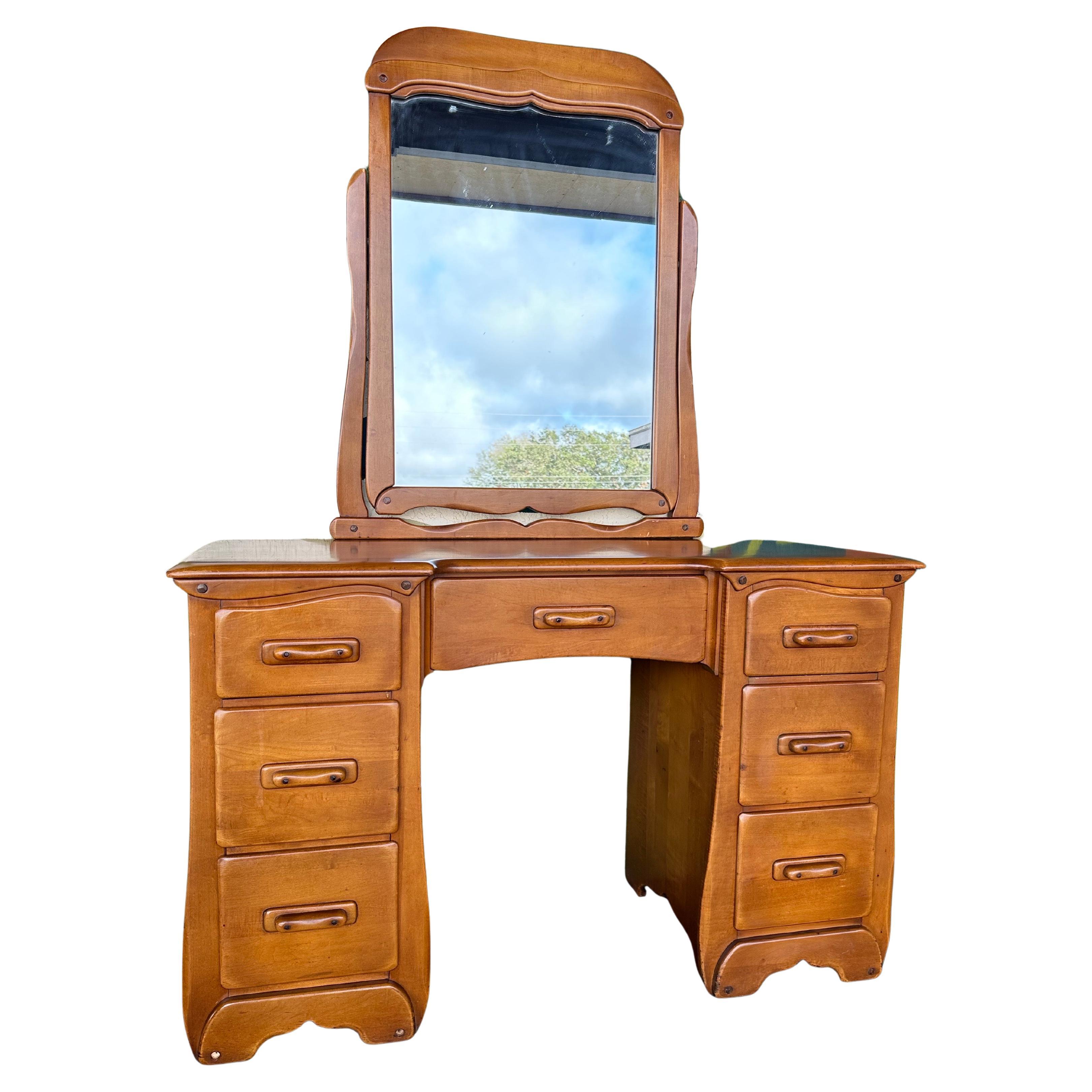 Mid Century Colonial Style Solid Maple Knee Hole Vanity with matching bench and mirror. Maker unknown, American made stamped “42 MAPLE” on back, likely circa 1950’s. Whimsical shape and detailing, curved top drawers with accenting trim, dovetail