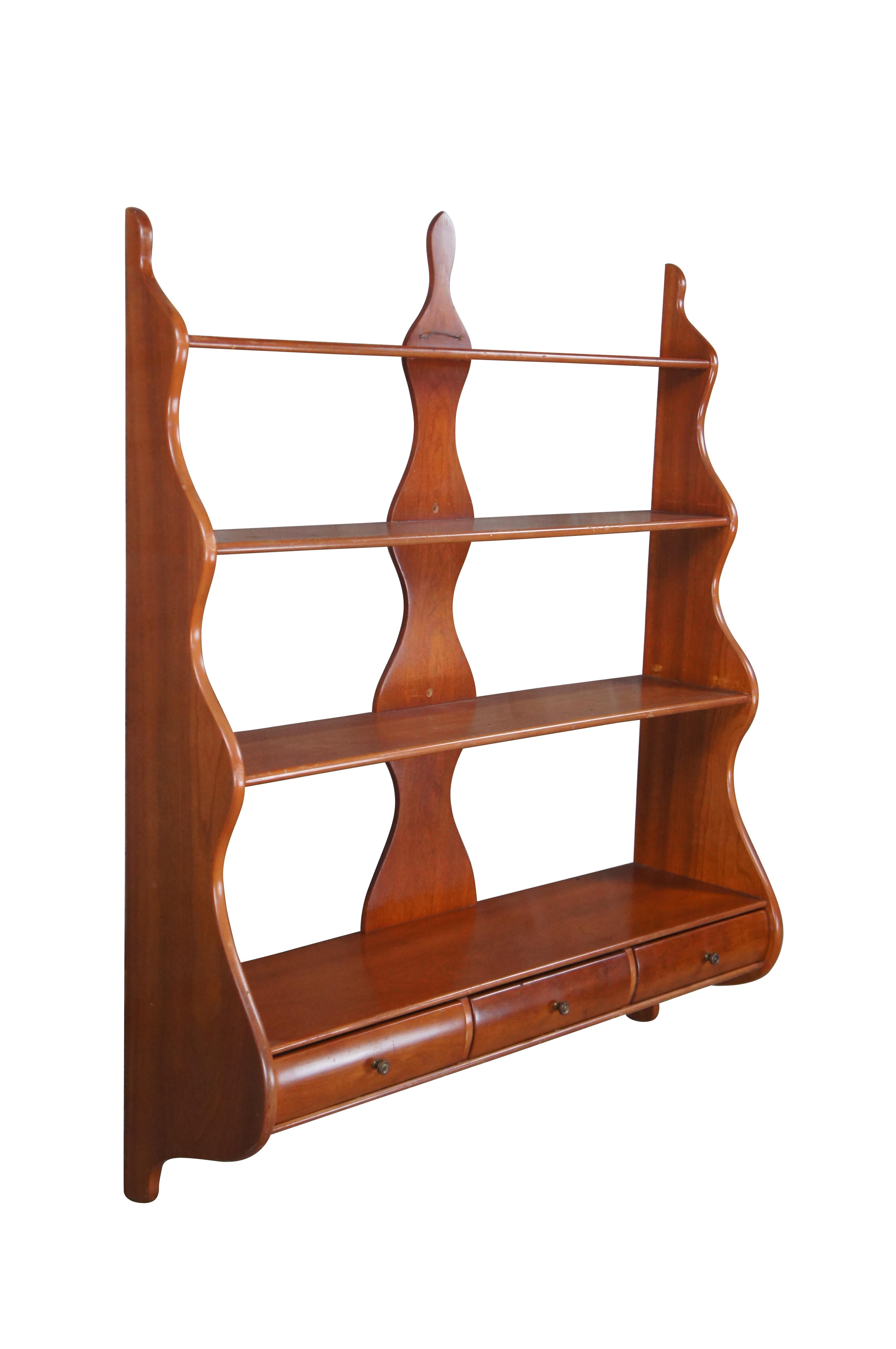 A large and impressive mid 20th century serpentine wall shelf. Made from solid cherry with four graduated tiers and three drawers with rabbet joint construction.

Dimensions:
32.75
