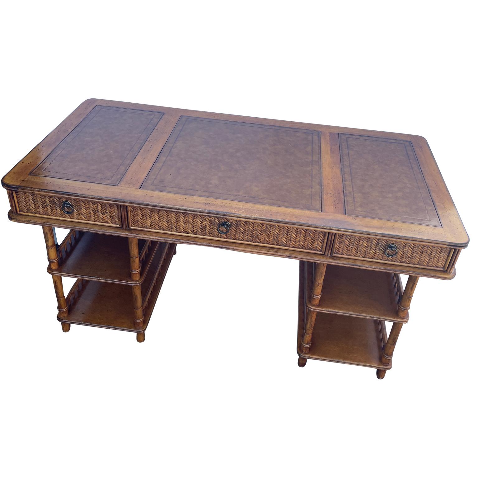 Faux bamboo writing desk in colonial style with leather inset top

A British Colonial style writing desk with decorative rattan and bamboo pattern and leather inset on writing surface. Maker's mark to interior of top drawer. This is a beautiful