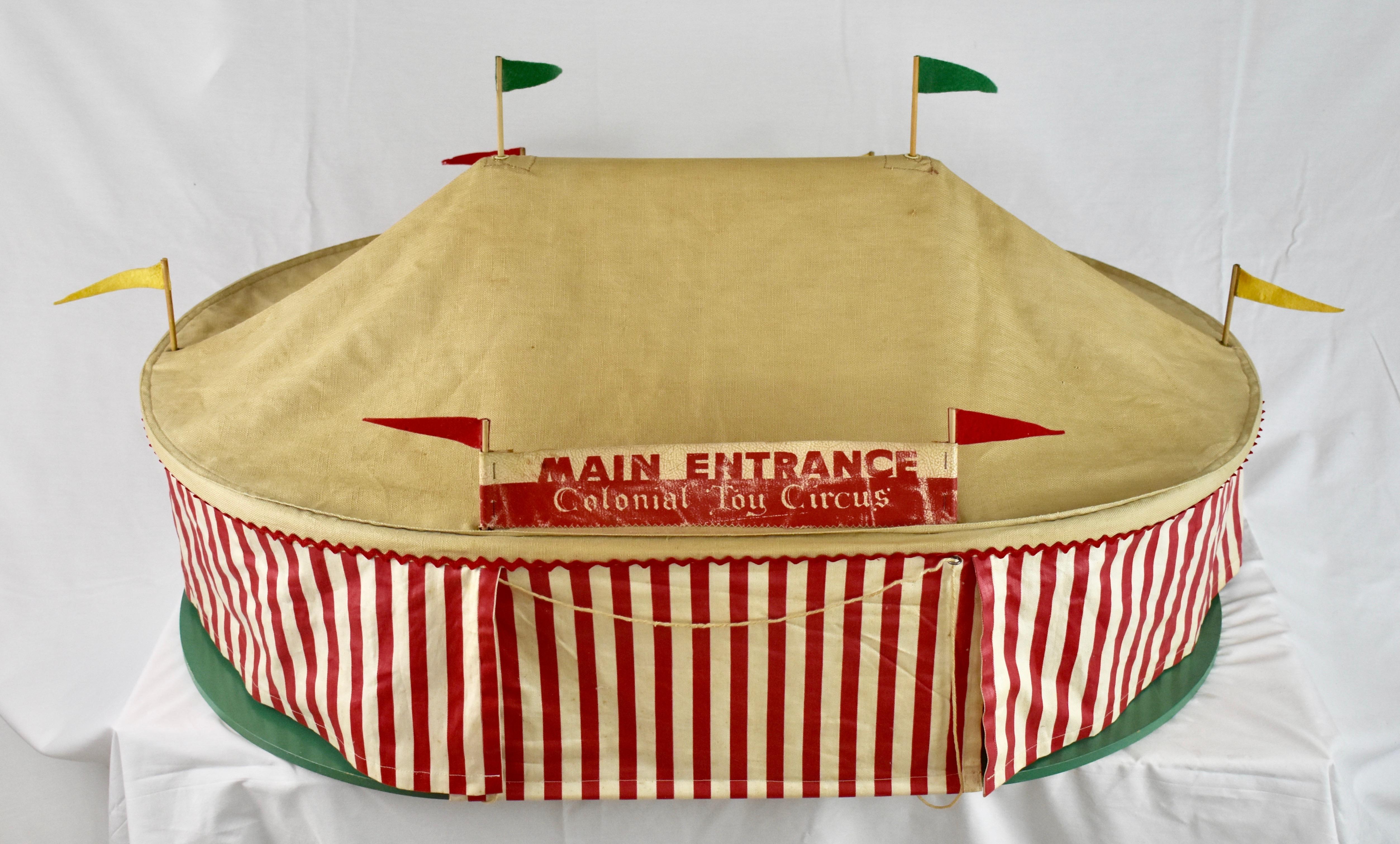 This is an extremely rare toy circus, the “Colonial Toy Circus” by Allison Designs of Oak Park, Illinois. The set, which we do not claim is complete, is comprised of a canvas big top mounted on a 0.5” thick wooden base. The interior floor has a