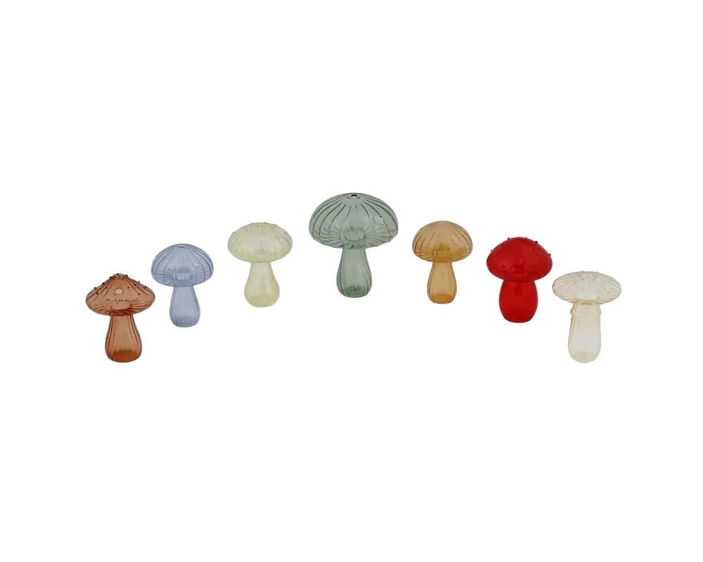 A set of seven vintage color glass vases modeled in the shape of mushrooms with pierced tops, showcasing a delightful and imaginative design. Crafted with meticulous attention to detail, the vases capture the essence of natures beauty and translate