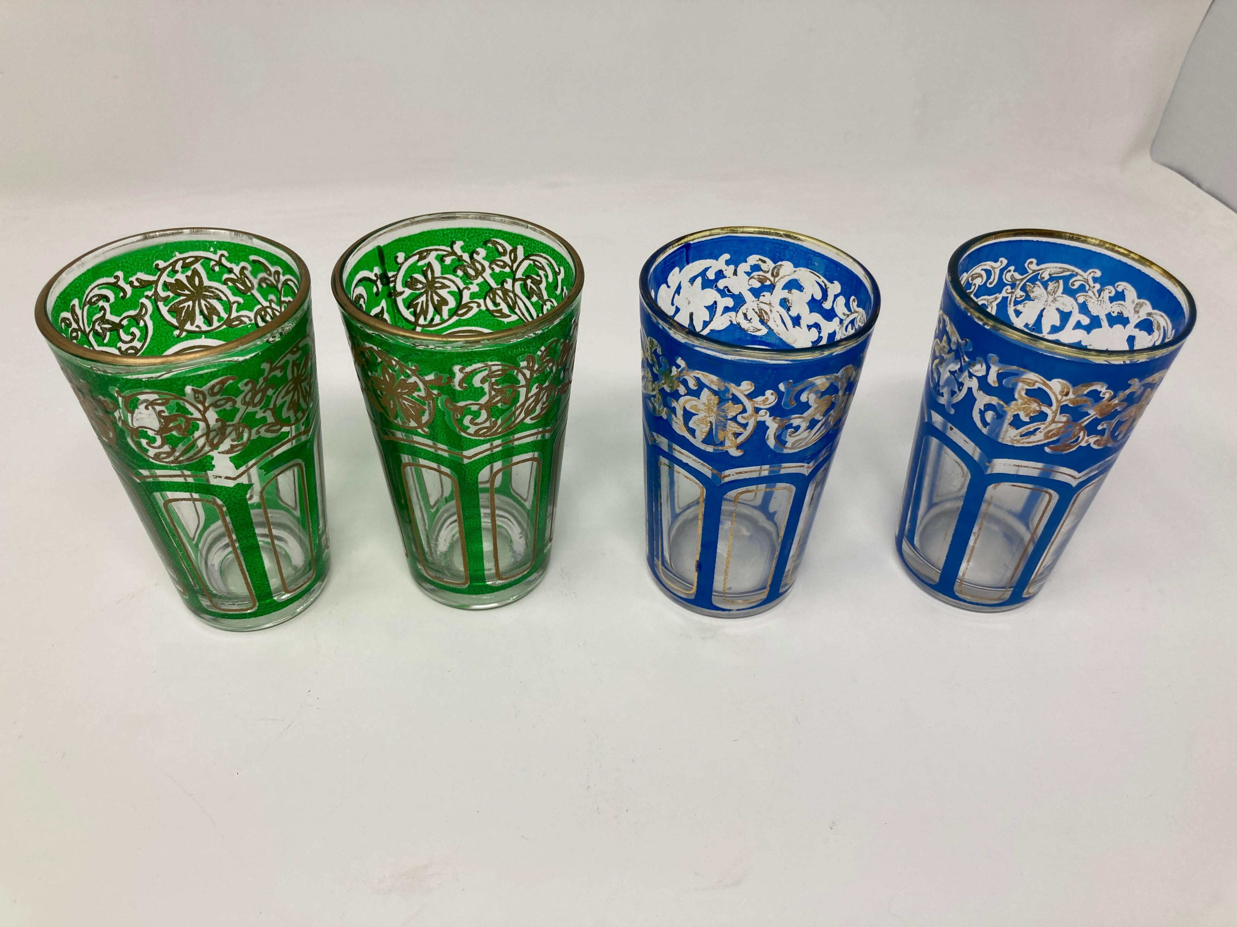Set of four vintage Moroccan colored glasses with gold raised Moorish design. 
Decorated with a classical gold and pattern Moorish frieze. 
Use these elegant vintage shot glasses for Moroccan tea, or any hot or cold drink. 
Perfect for the holidays