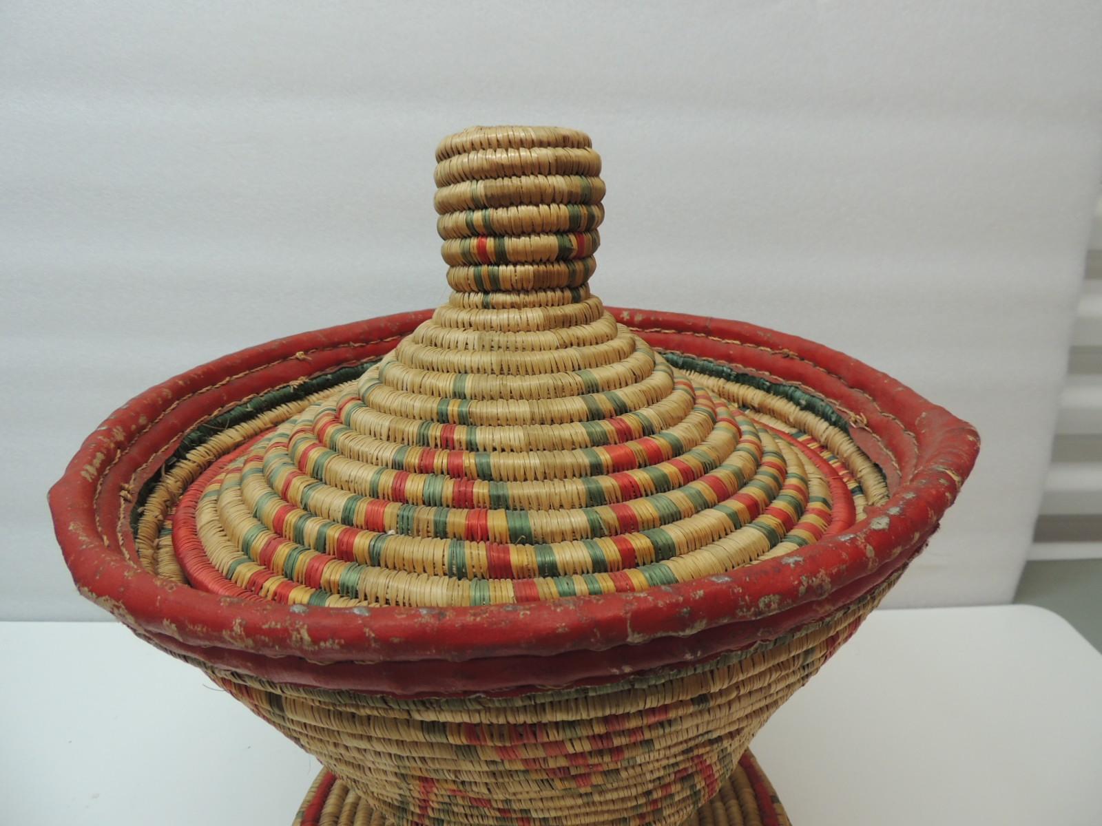 Vintage colorful African round basket with Lid. Round handwoven artisanal basket.
In shades of orange, red and blue.
Size: 13