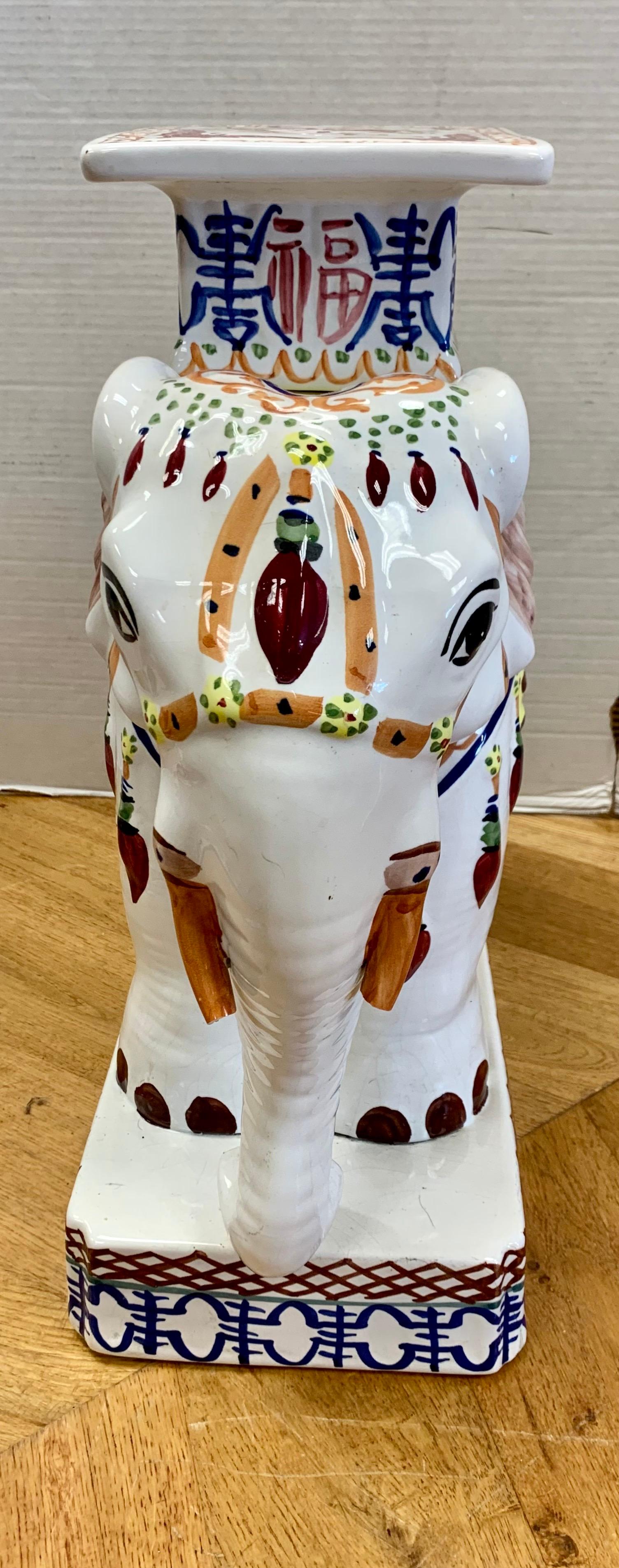 Colorful Chinese porcelain elephant garden seat stool in the shape of an elephant decorated in ornate oriental finery. It is hand painted in a colorful palette in blue, yellow, peach and white.