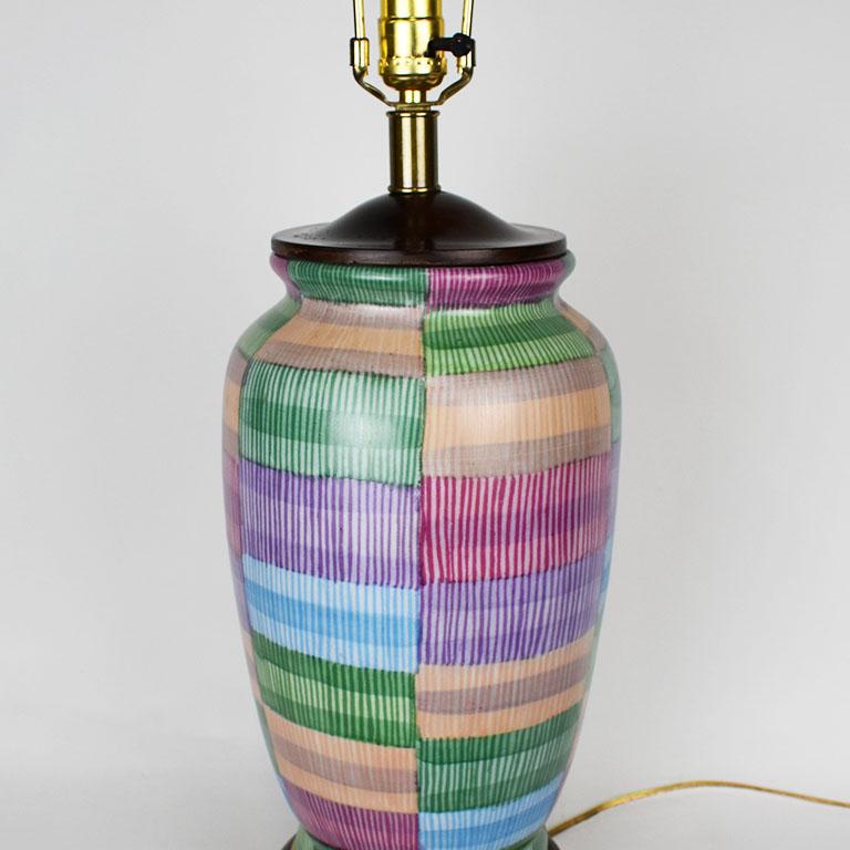 A beautiful tall vintage colorful ceramic table lamp by Frederick Cooper. This beauty sits upon a wooden chinoiserie style base in a deep brown, with brass accent rim. The body is painted in blocked rectangular shapes in various hues of purple,