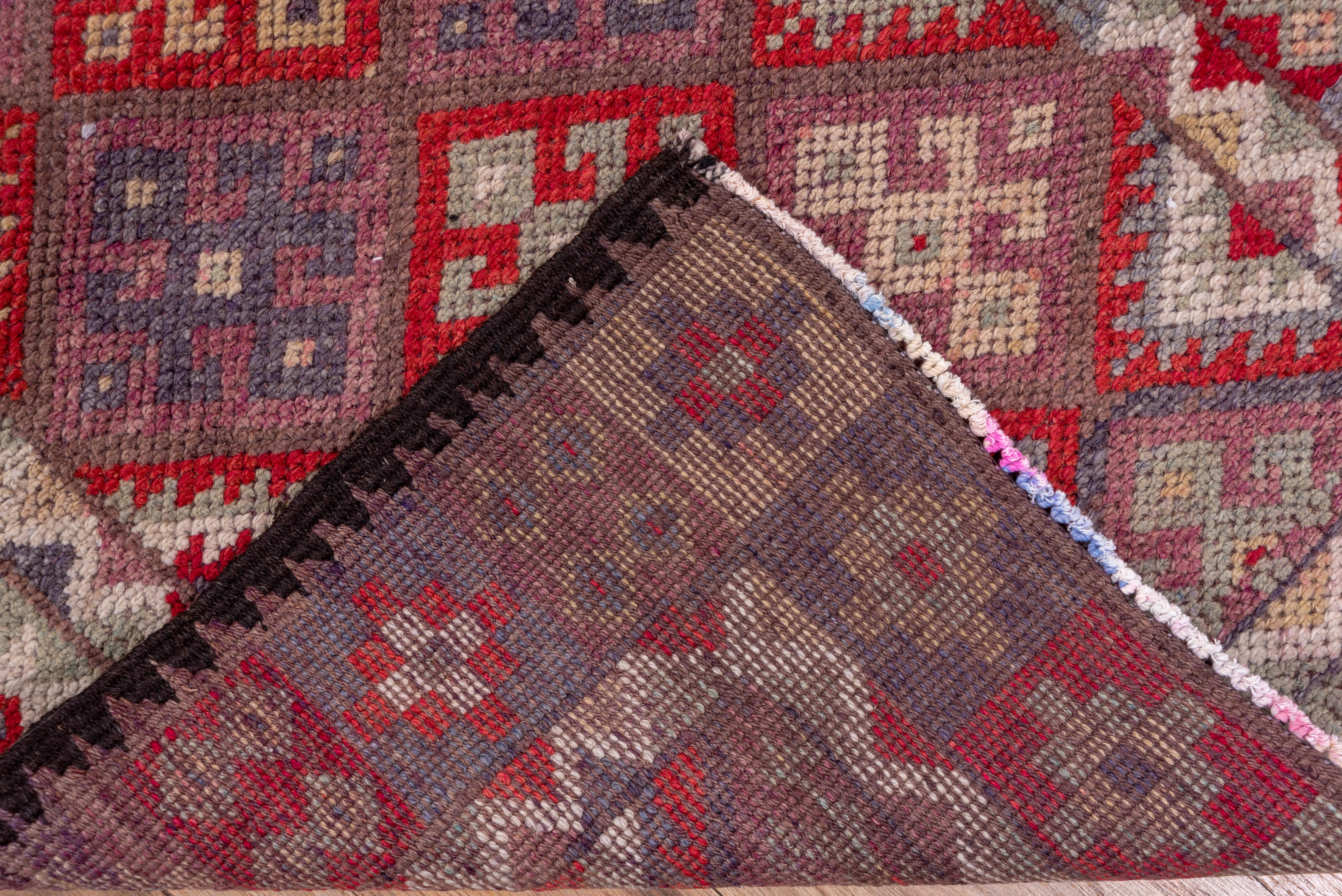 Dieser relativ moderne, gut erhaltene, große Knotenläufer hat sein buntes Rautenmuster von kurdischen Jaffi-Taschen und -Teppichen. Die breite Palette umfasst Teal, Stroh, Hellblau, Rot-Braun, Elfenbein und Buff. Die Umrandung besteht aus Quadraten
