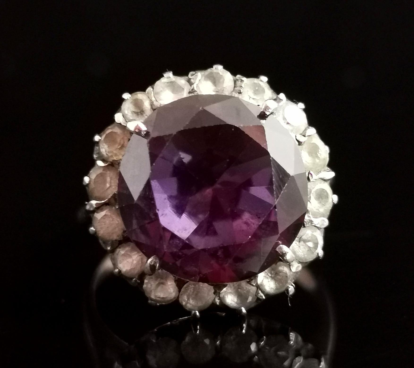 A fantastic vintage, retro era, c1940s Synthetic colour change sapphire and paste cluster ring.

This ring is all about that huge centre stone, it is a faceted round cut gemstone with a large table, surrounded by a halo of white paste stones, giving