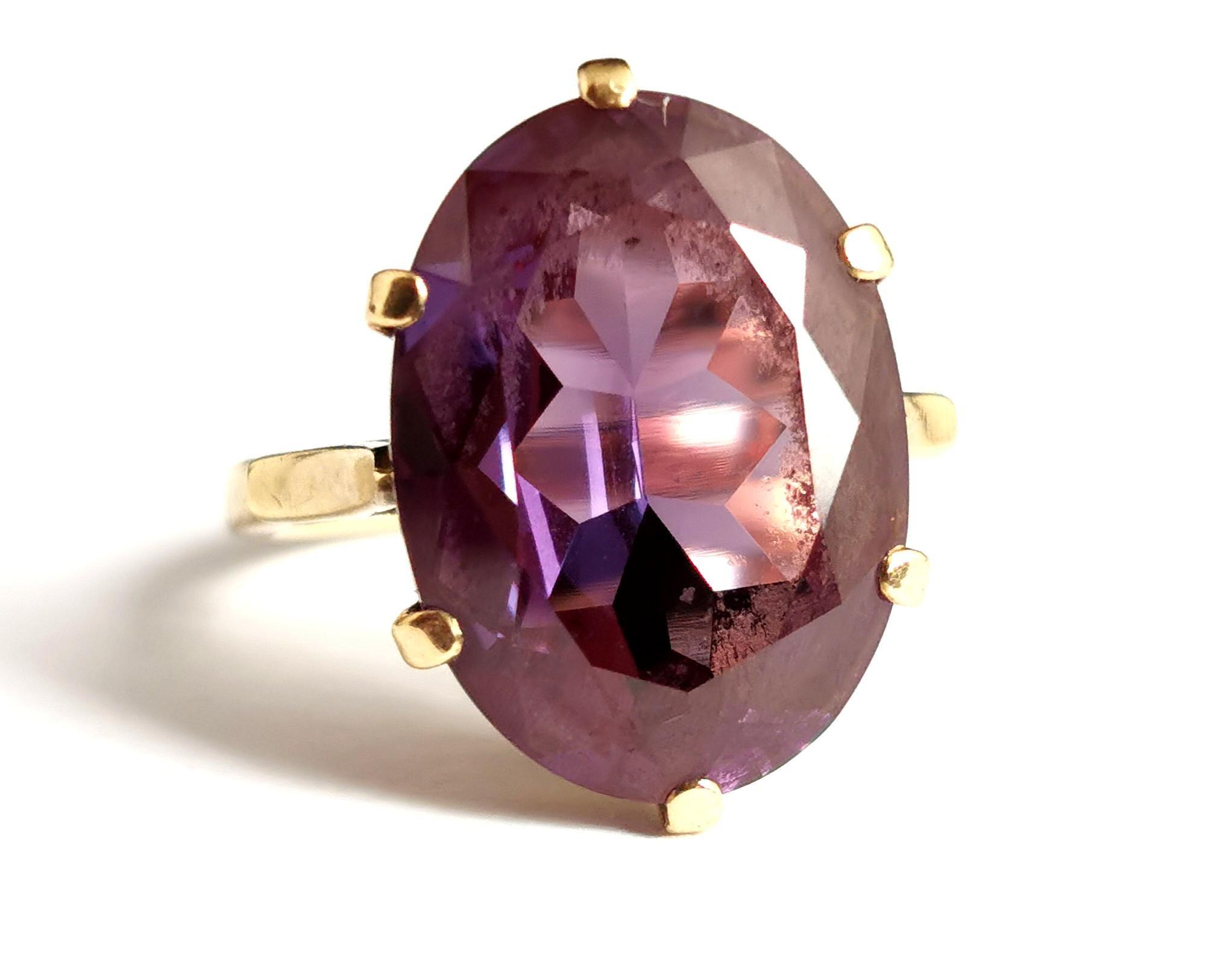 A gorgeous vintage 1970s era, Synthetic colour change sapphire or Alexandrite ring.

This ring is all about the centre stone, it is a faceted oval cut gemstone with a large table.

The stone has a beautiful array of tones in different lights ranging
