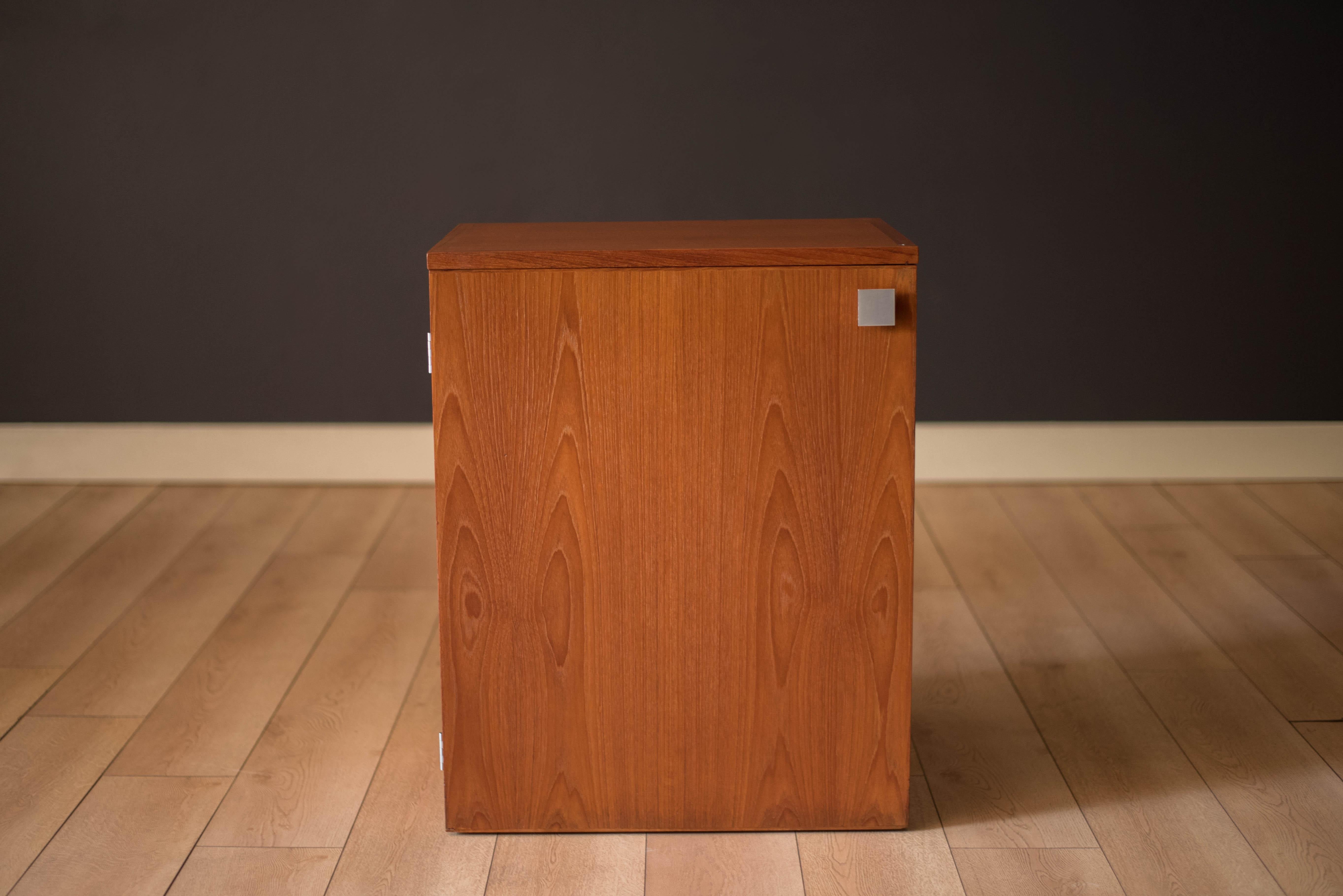 Mid-Century Modern compact dry bar cabinet in teak model no. 7739 manufactured by Dyrlund, Copenhagen. This clever piece features an extendable serving top with an easy to maintain black laminate surface. Equipped with two dovetail drawers, a