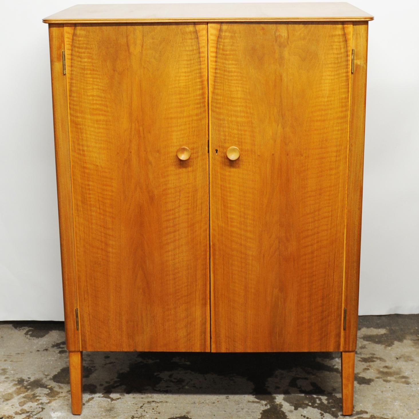 A mid-century modern compact wardrobe made by Gordon Russell. Features a sliding closet rod and built-in shelves.

Manufacturer - Gordon Russell

Design Period - 1960 to 1969

Country of Manufacture - U.K

Style - Mid-Century

Detailed Condition -