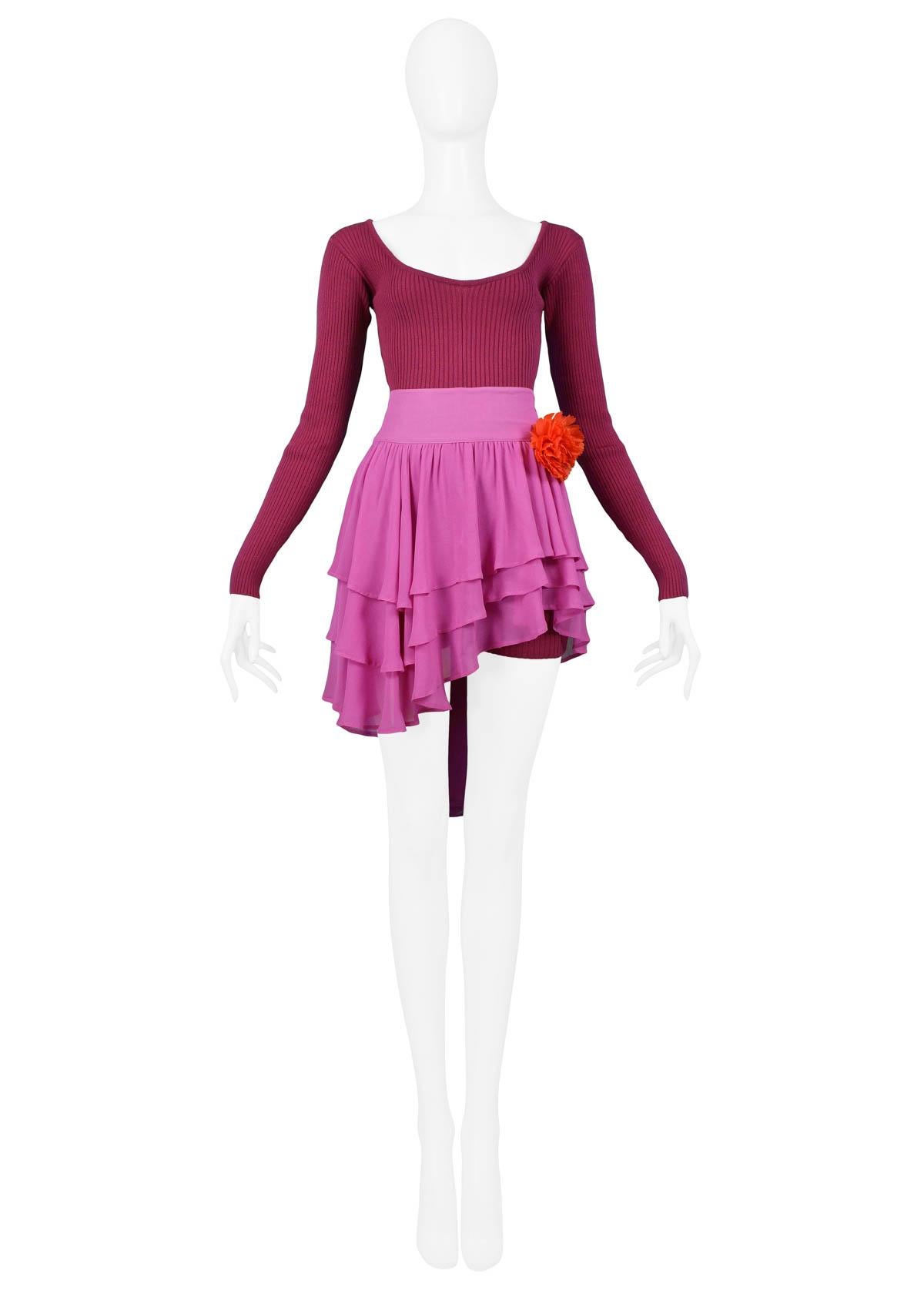 Vintage Complice pink chiffon skirt and magenta bodysuit shorts ensemble. The chiffon three-tier skirt features hook and eye closure at the side, an attached belt that ties into a bow, and attached flower. Rib-knit bodysuit features low cut