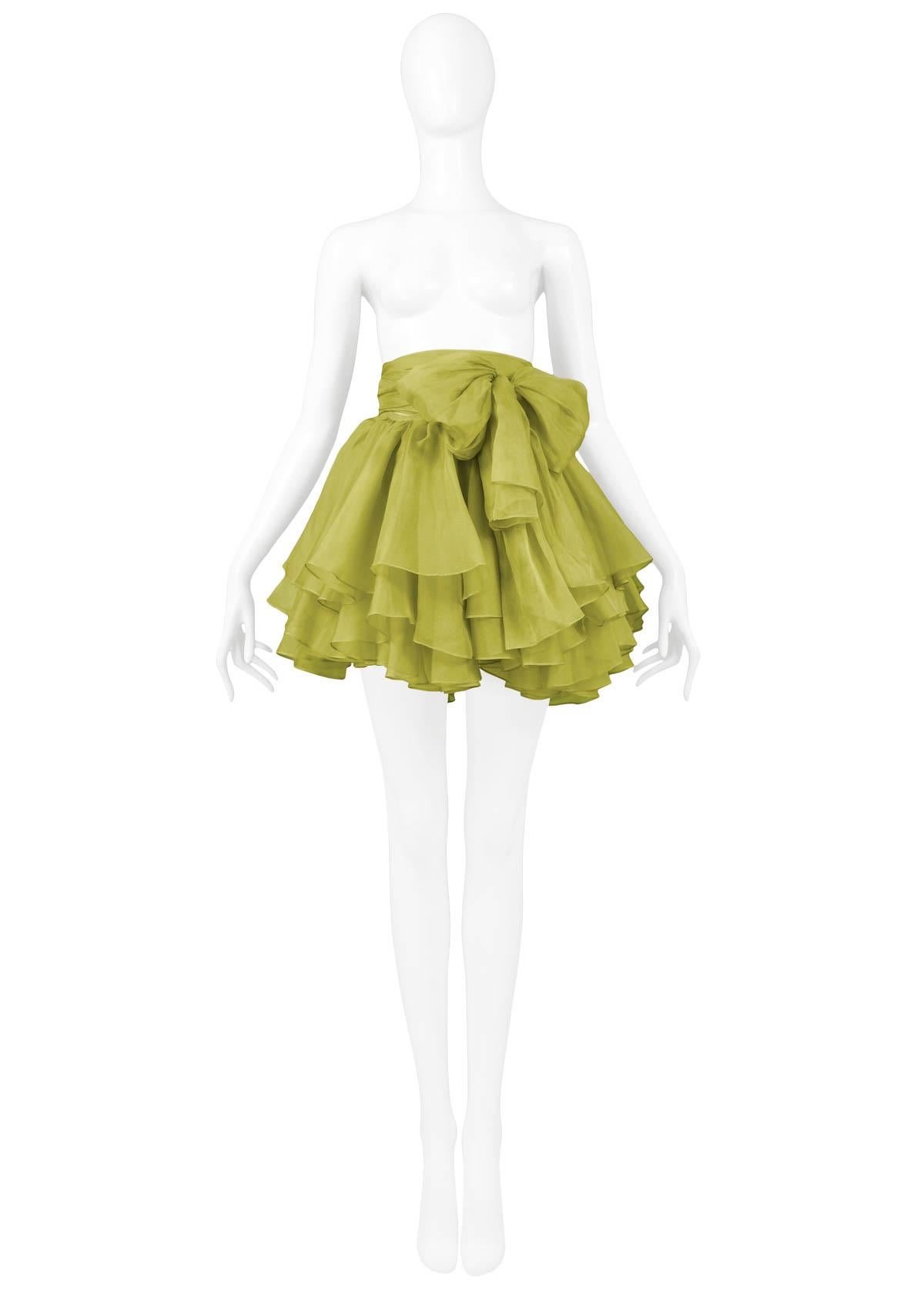 Vintage Complice green organza wrap-around pouf skirt featuring an adjustable waist, ruffles, and attached belt that ties into a bow. From the 1991 Collection.  This skirt has holes along the waistband's wrap ties of the skirt connecting to the