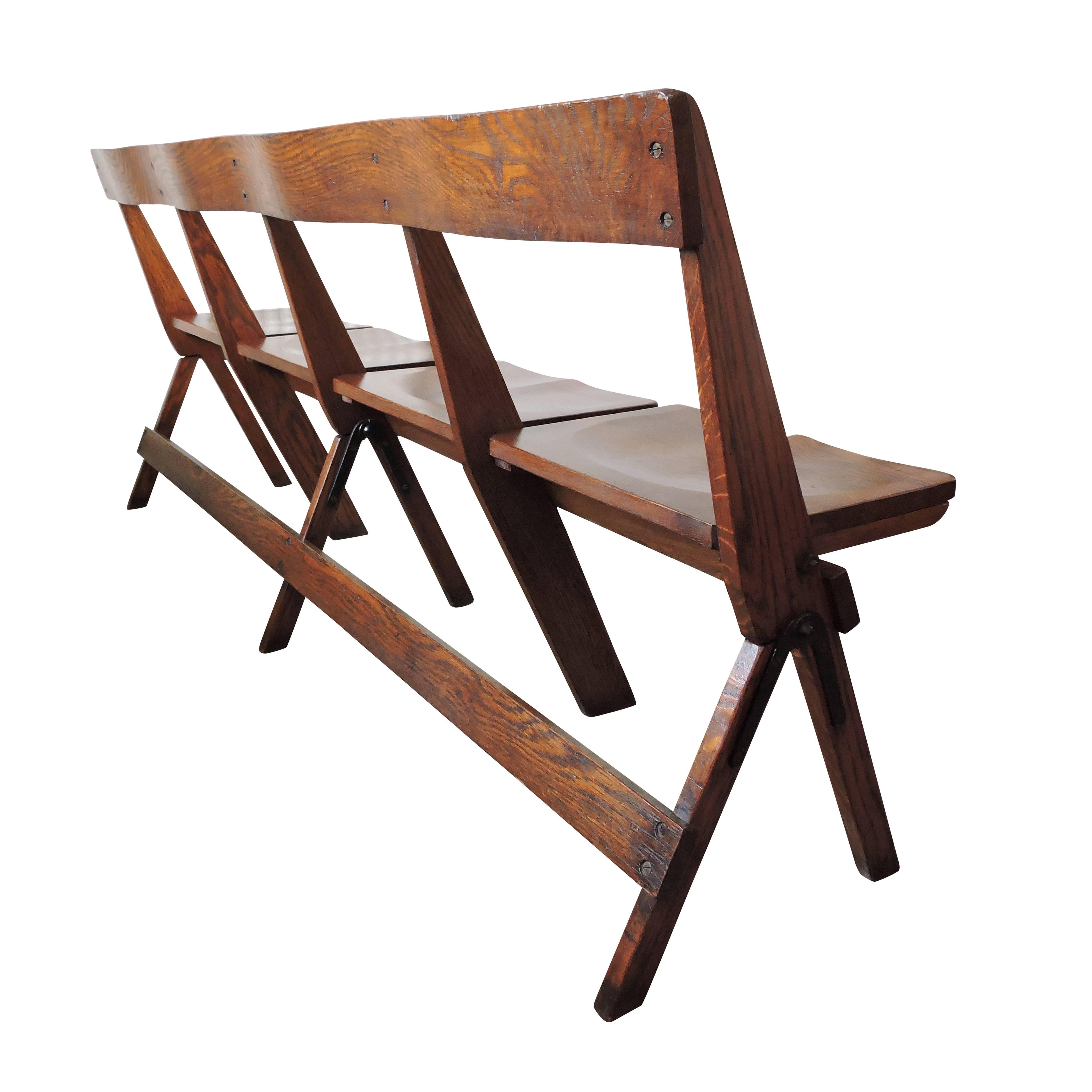 This set of four conjoined oak folding chapel chairs features individually folding solid seats.