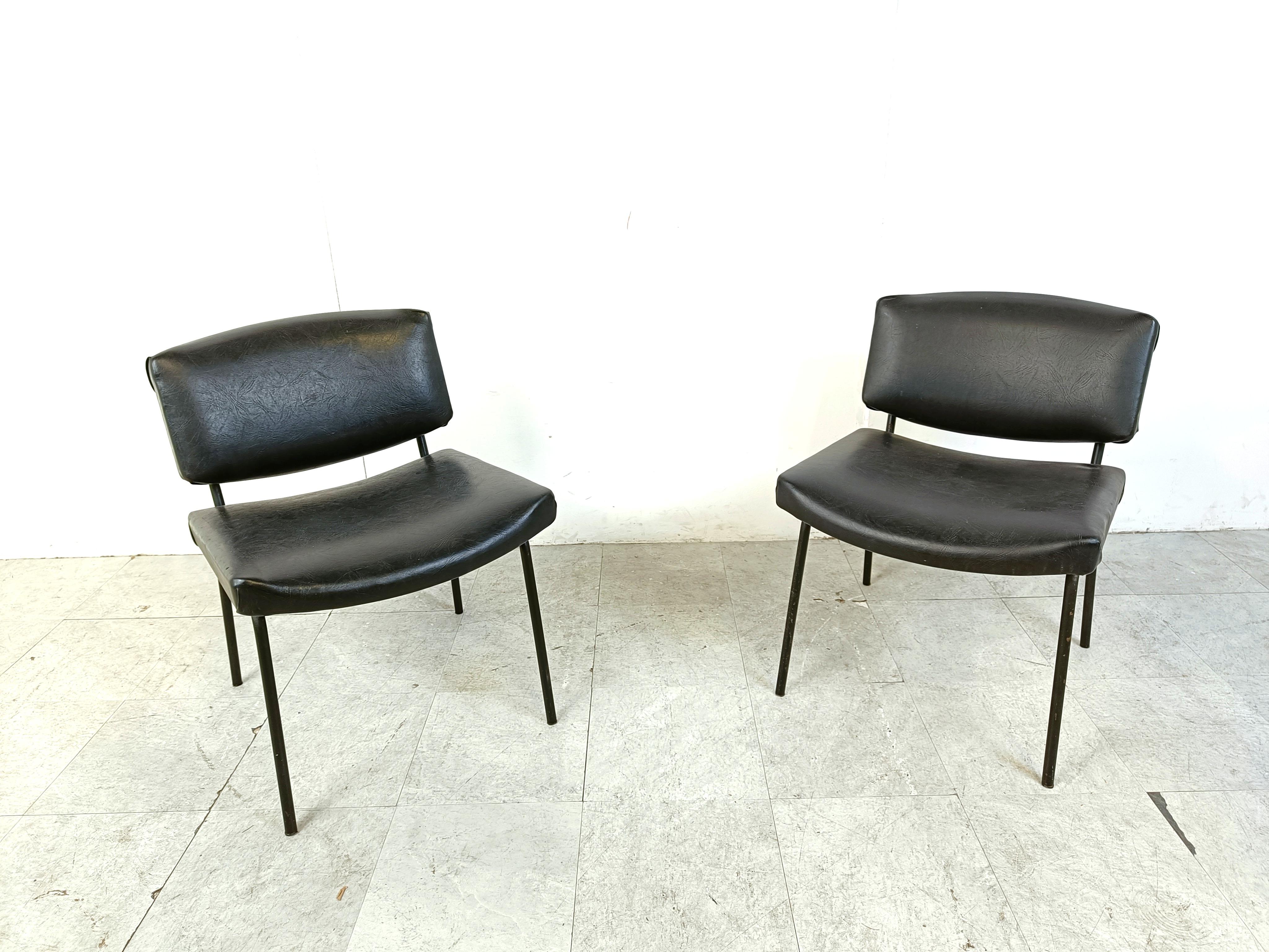 Ensemble de deux chaises 'conseil' de style moderne du milieu du siècle dernier, conçues par Pierre Guariche pour Meurop.

Les chaises ont un cadre laqué noir et sont revêtues de leur simili-cuir ou de leur skaï noir d'origine. 

Les chaises sont en