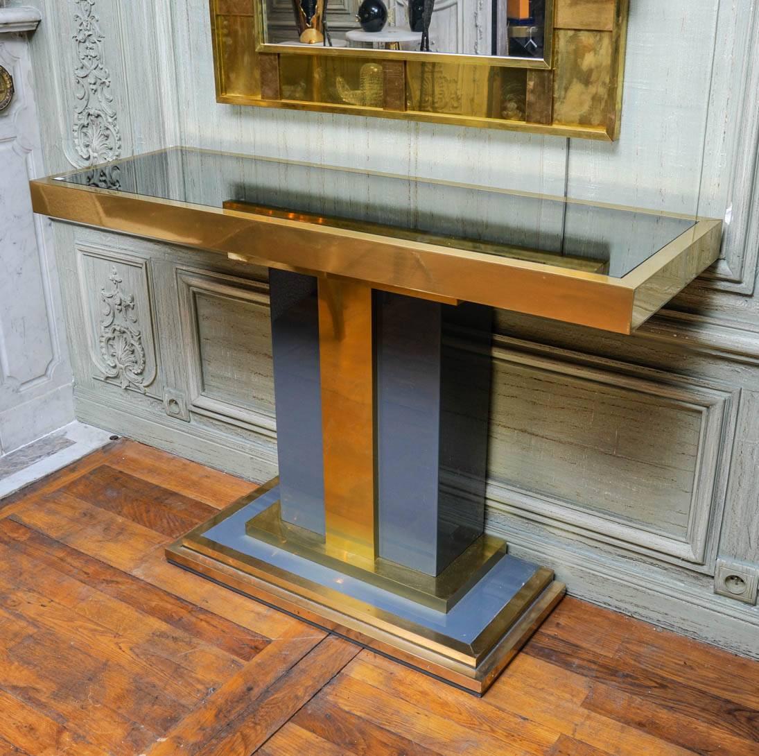 Vintage console made of brass and grey lacquered wood, topped with smoked mirror.


      