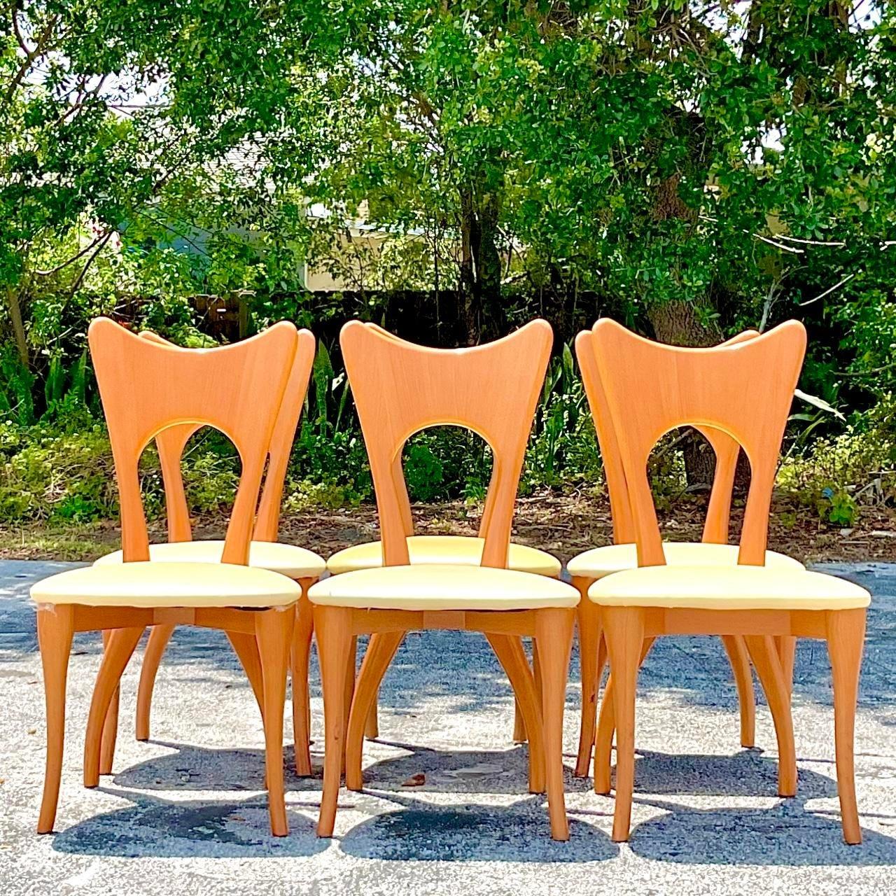 Infuse your dining space with timeless American charm using this set of 6 Vintage Contemporary Blonde Biomorphic Dining Chairs. Crafted with sleek lines and a nod to organic forms, they effortlessly blend classic elegance with modern sensibilities,