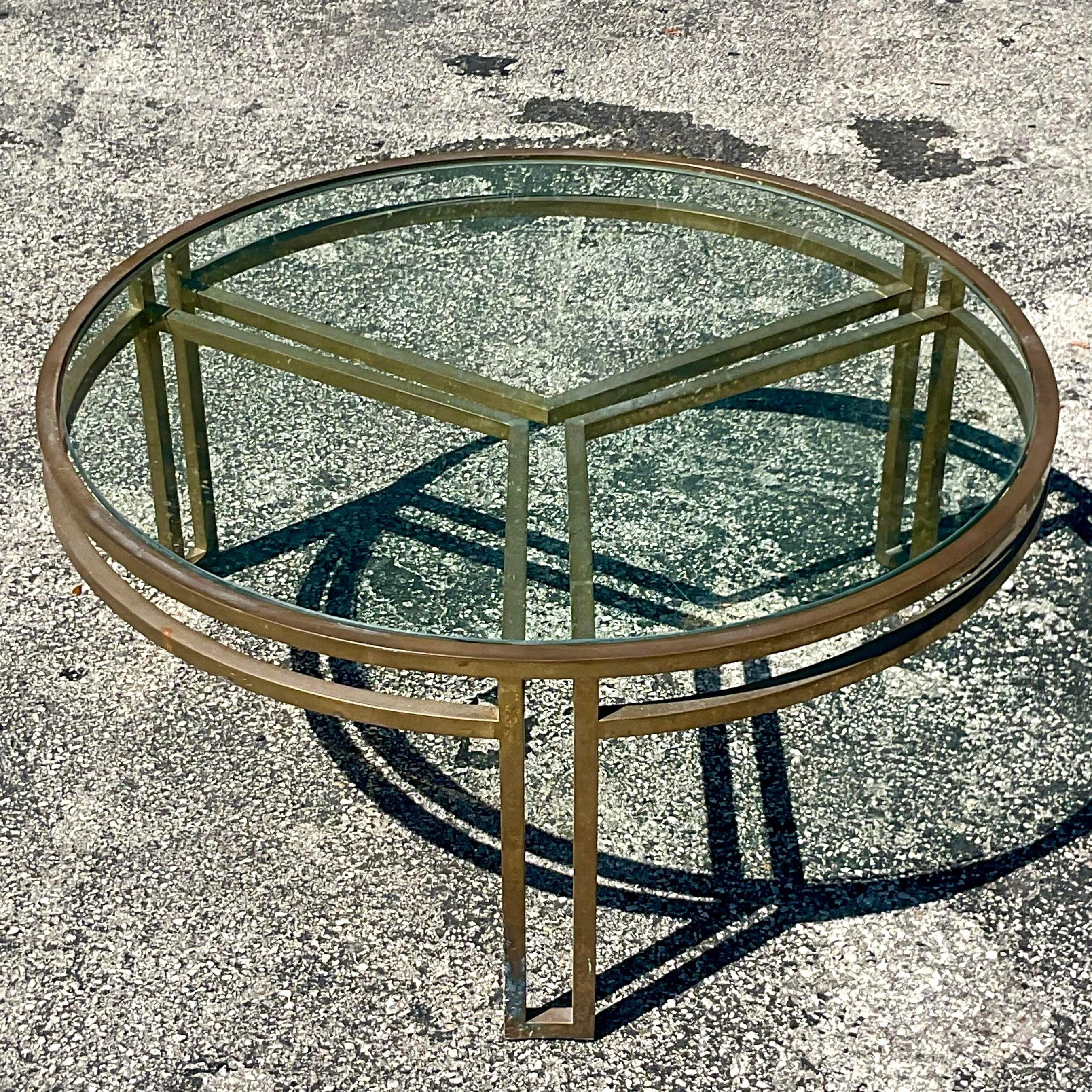 A fabulous vintage Coffee table. A chic Contemporary design in brass with an inset glass top. Acquired from a Palm Beach estate.