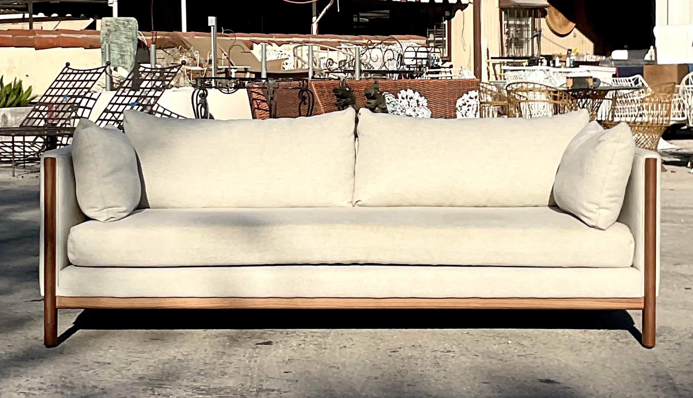 A fantastic vintage Contemporary sofa. Made by the Design Within Reach group. The popular “Emmy” style with a wood detailed frame and clean design. Acquired from a Palm Beach estate.