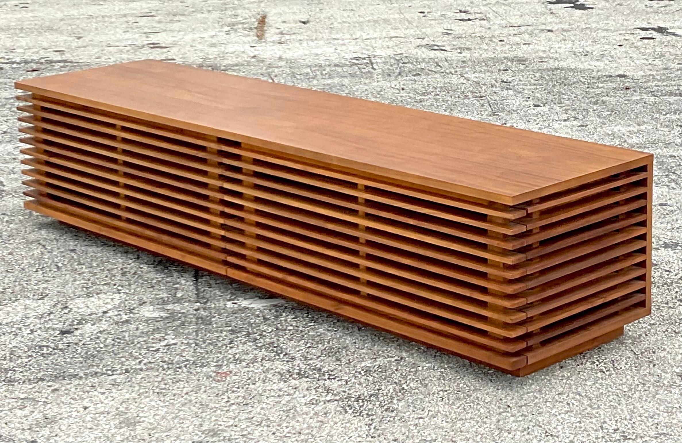 A fantastic vintage Contemporary low credenza. Made by the Folks Furniture group and tagged inside the drawer. A chic slatted design with a low profile that is perfect for your gigantic flat screen TV! Acquired from a Palm Beach estate.