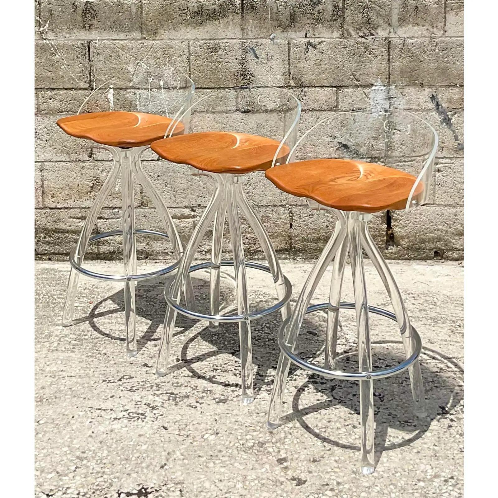 Fantastic vintage Contemporary set of three barstools. Made by the iconic Hill Company. Chic lucite frame with wood saddle swivel seats. Acquired from a Palm Beach estate.